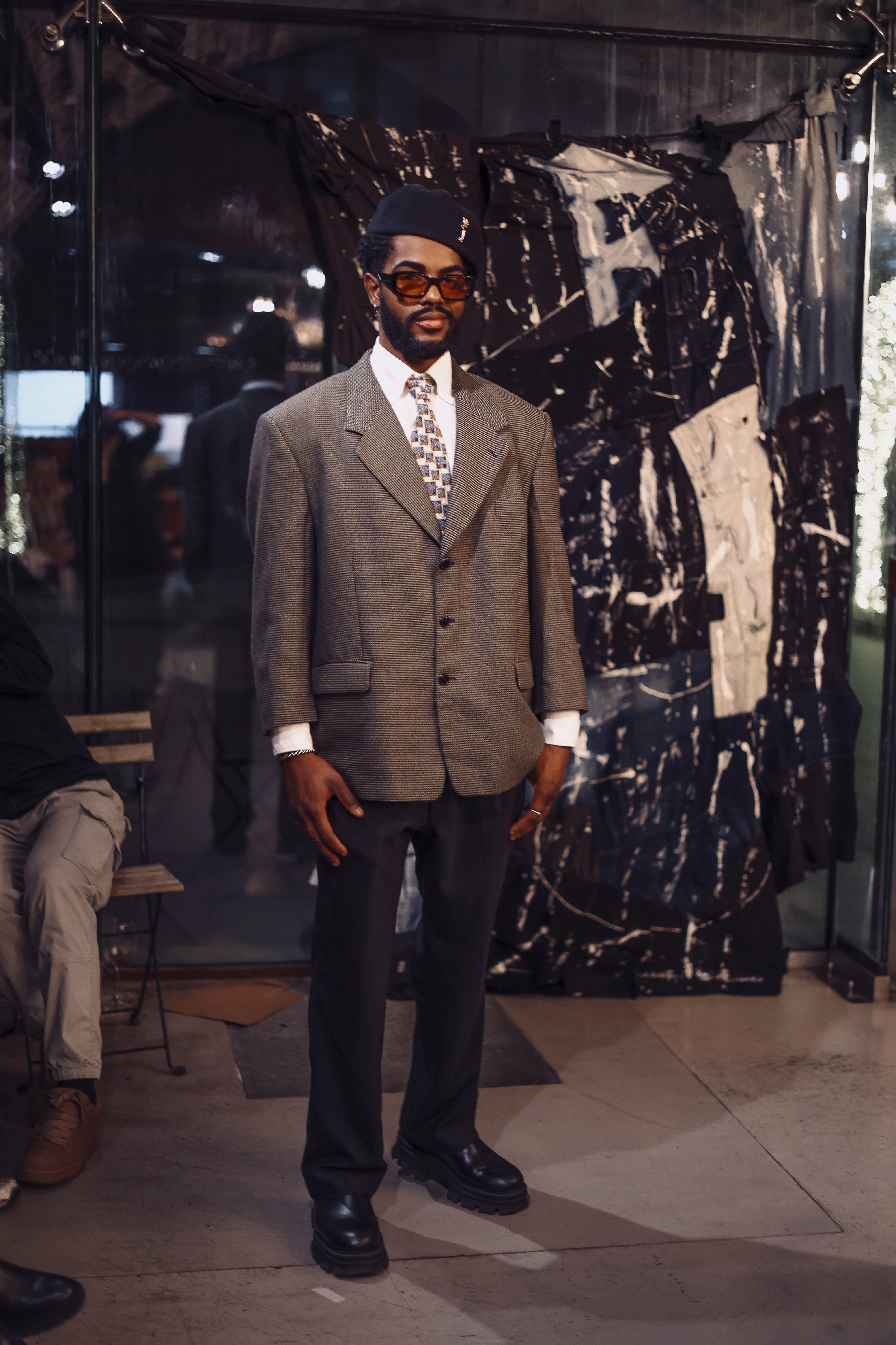 Woman in red outfit poses by a red telephone booth.
