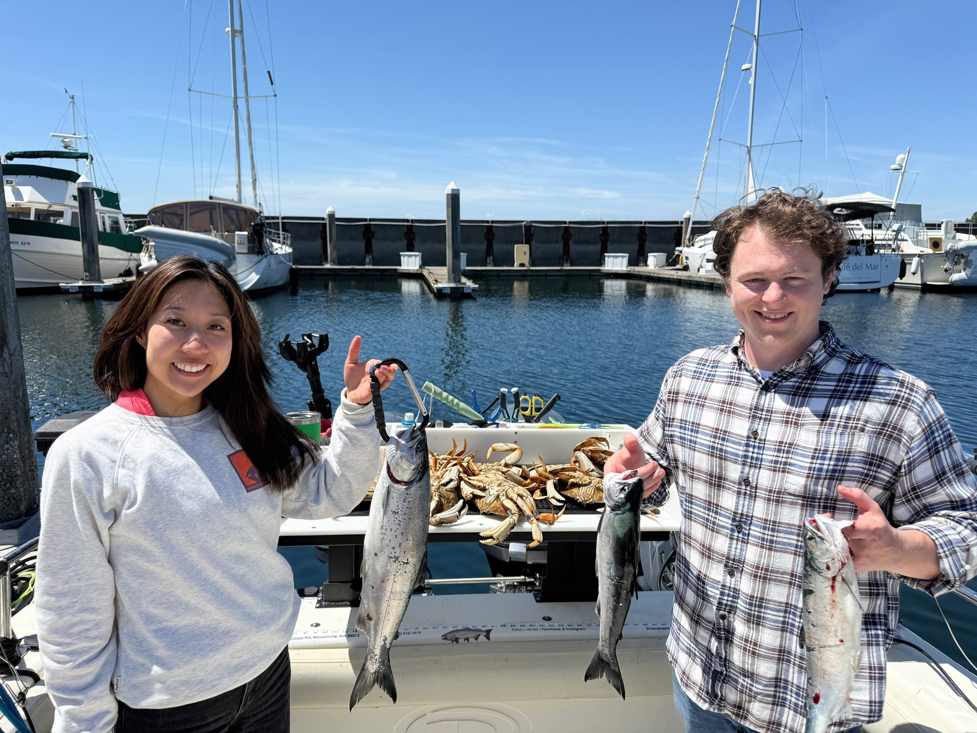 Couple with salmon and crab on Puget Sound Seattle fishing charter.
