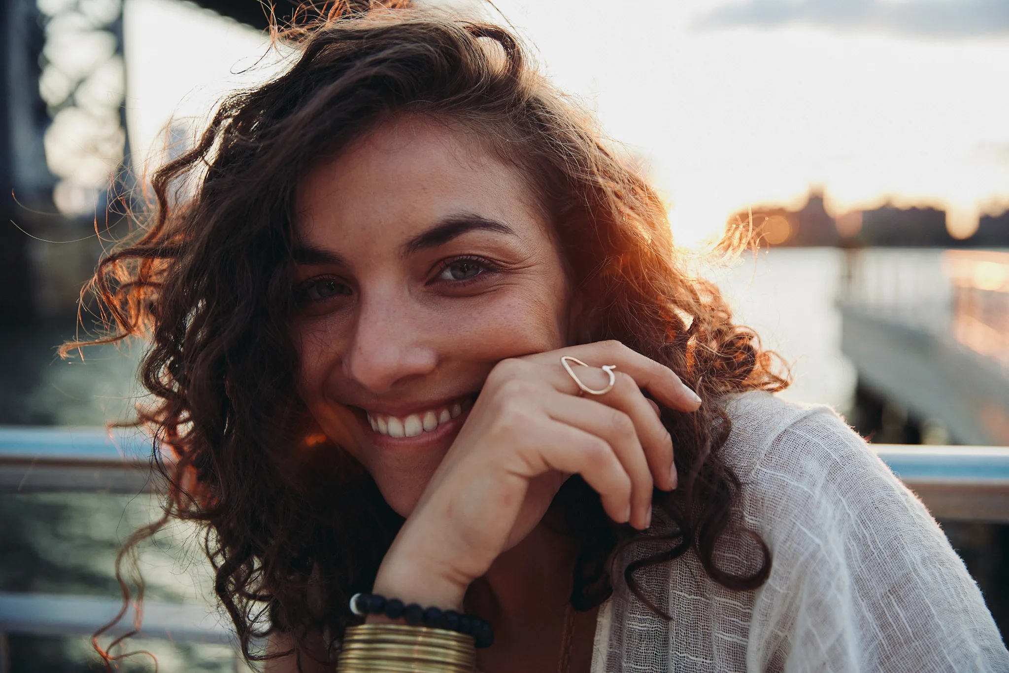 woman resting chin on hand at sunset — portrait photography by Tom Kubik