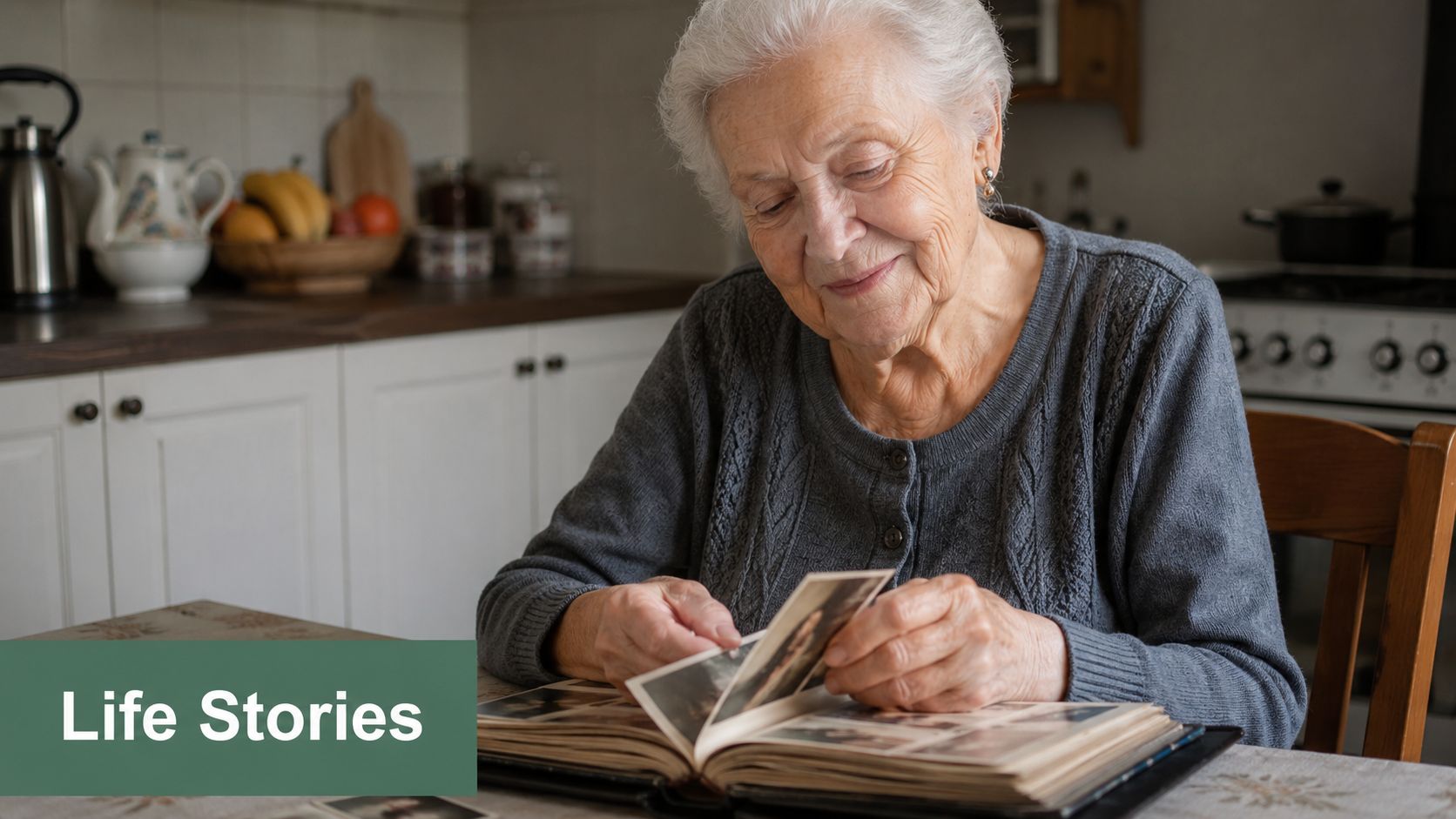 An elderly woman with white hair smiling as she looks through a vintage photo album in her kitchen.