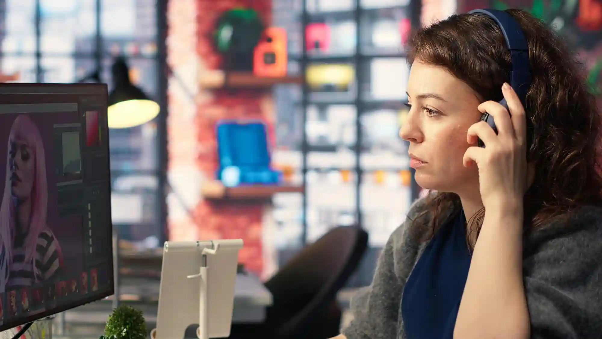 A digital artist wears headphones while using AI-powered design software to create high-quality visual illustrations.