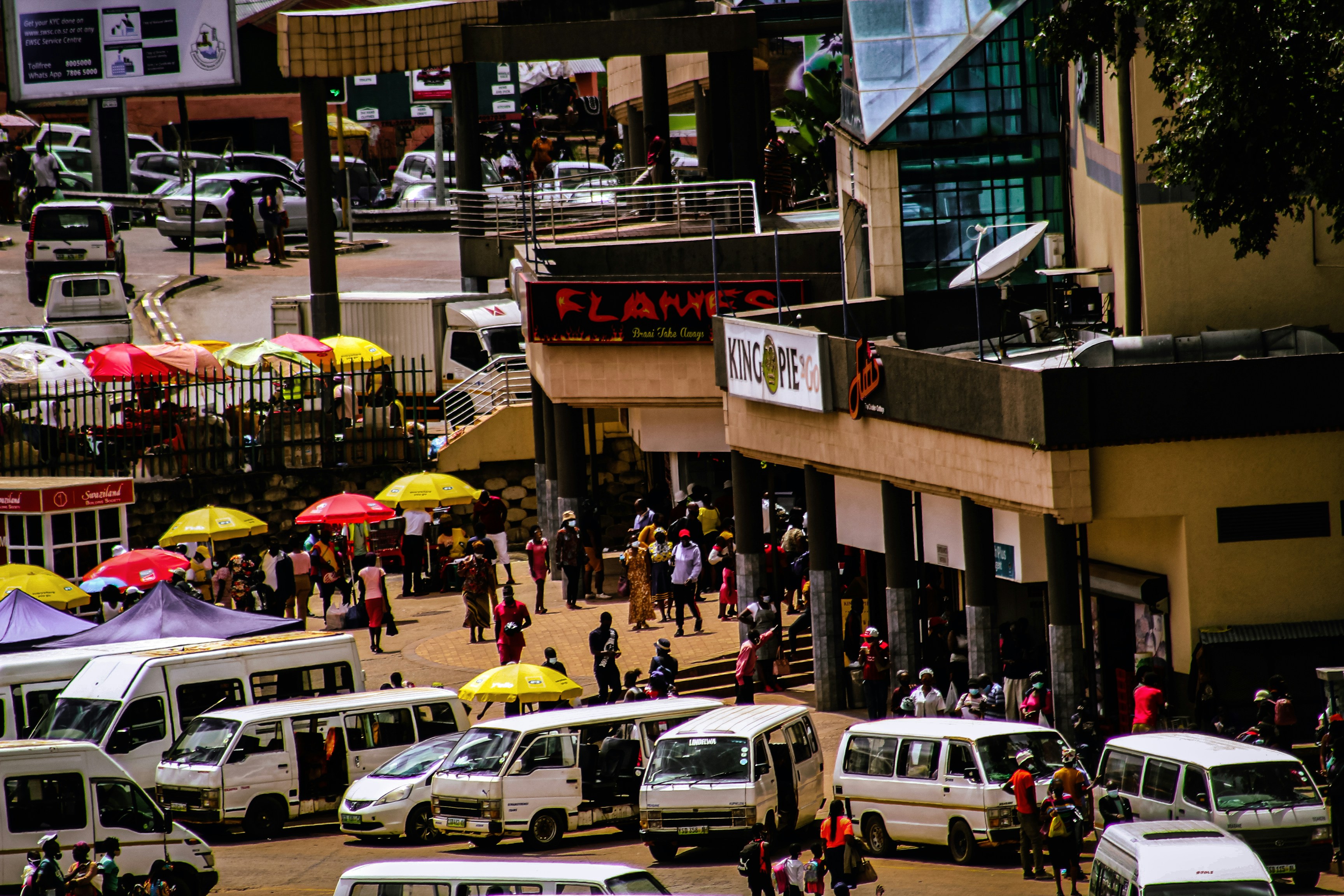 Bustling street market with vans and people