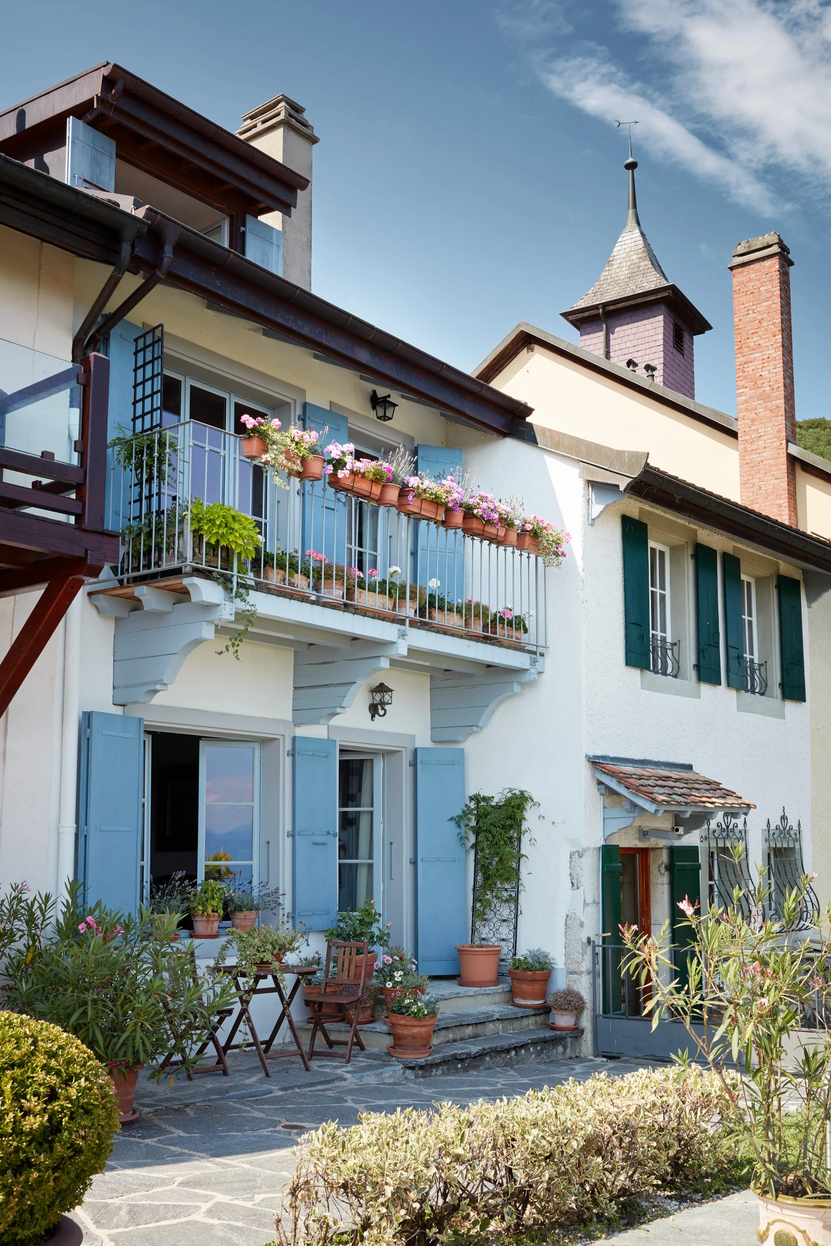 Façade lacustre de la maison de village à Bugnaux près de Rolle, au cœur des vignes, architecture traditionnelle aux couleurs douces et harmonieuses.