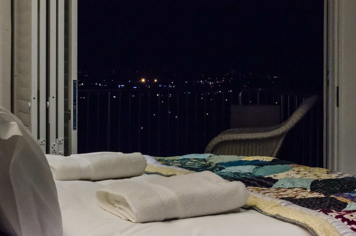 Image of the view from the bed overlooking False Bay at night from our 3-Way View Room