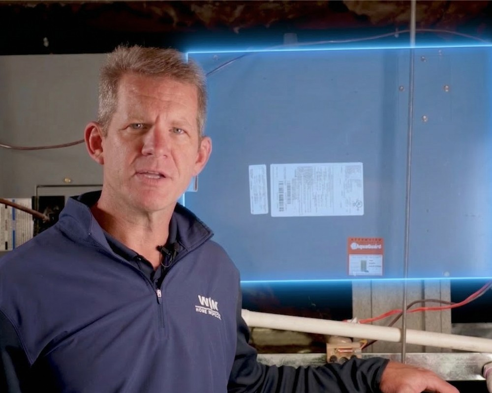A winding road cuts through rocky terrain, surrounded by patches of green grass and illuminated by sunlight.