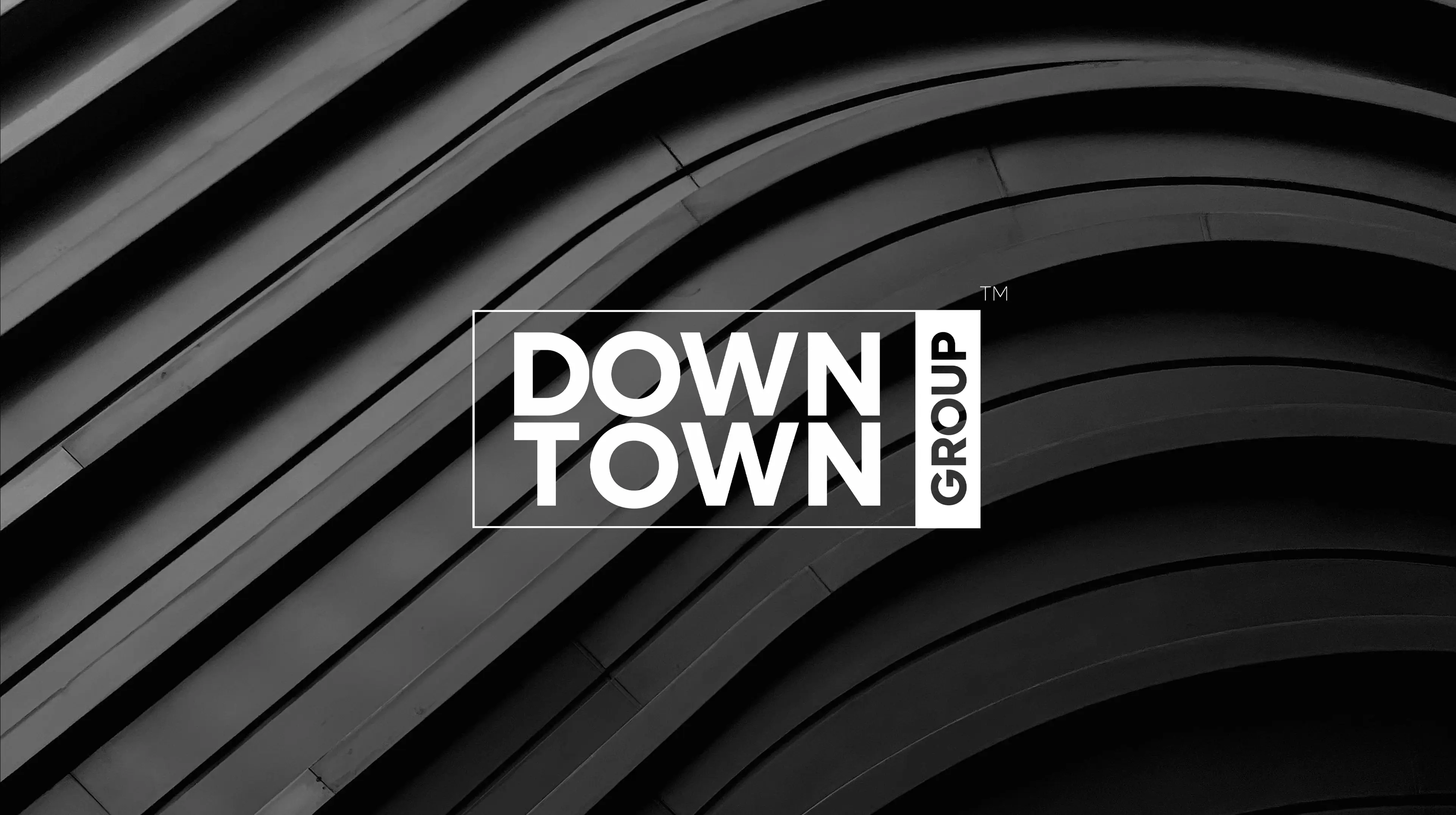 Downtown Group brand logo displayed on a dark background with modern diagonal wood slat architectural detail