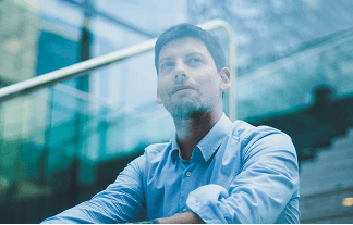 Person sitting in a modern office in front of a wall covered with notes and sketches.