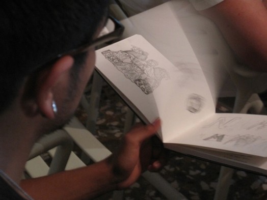 A photo of a person flipping a sketchbook.