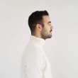 Profile portrait of a man in a white shirt against a light background