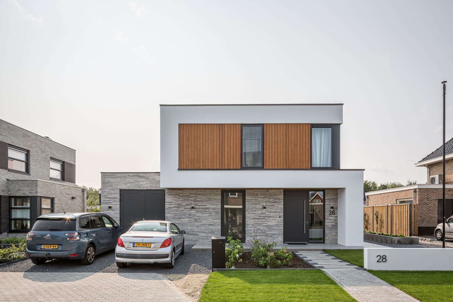 Strakke voorgevel van moderne villa in Apeldoorn met horizontale houten gevelbekleding