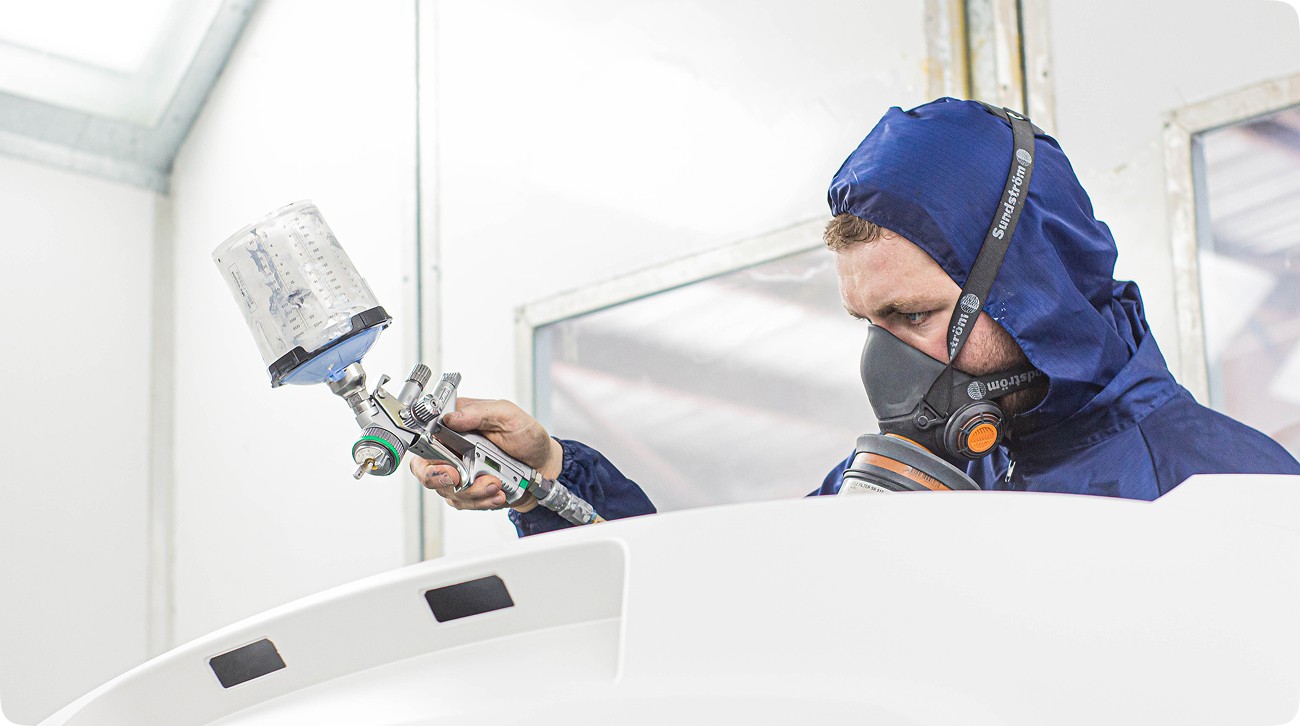 Painter in a spray booth with spray gun
