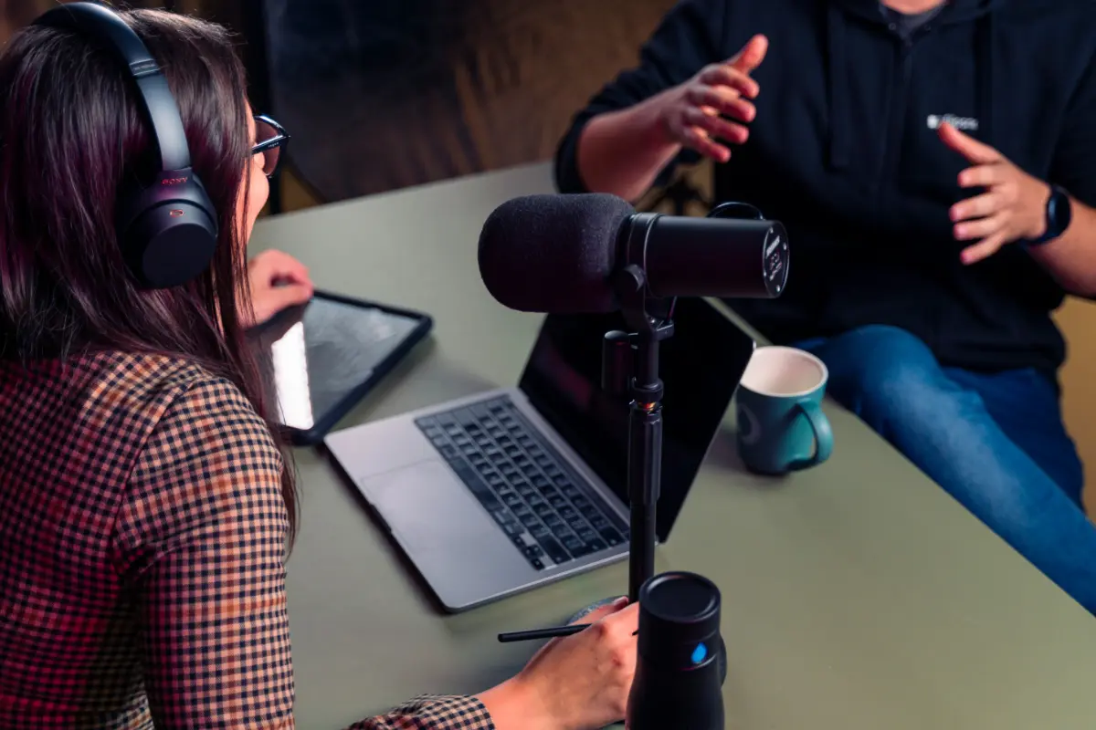 Corporate Podcasting, Ein minimalistisches Podcast Setup mit einem Laptop und Kopfhörern, zwei Personen unterhalten sich
