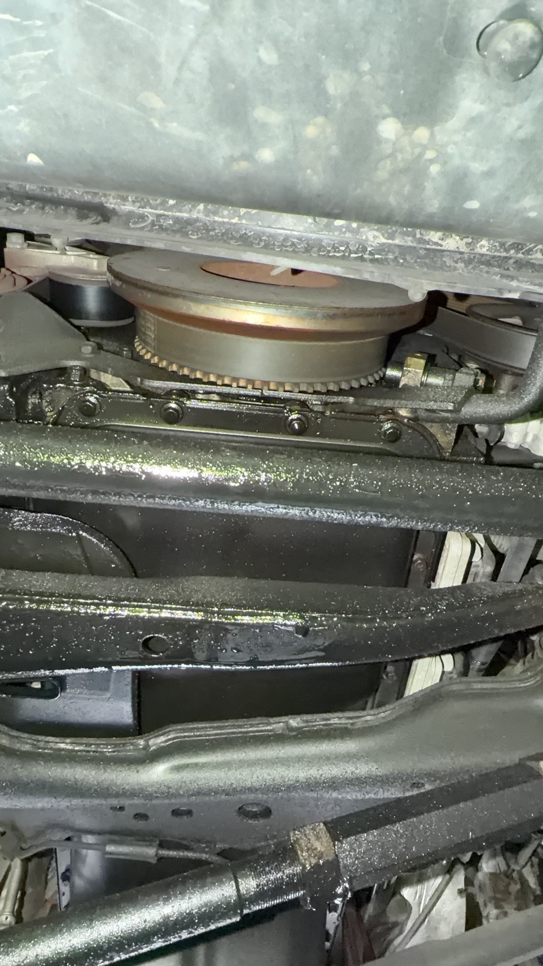 Underside of the Ram 2500 engine with oil coating the crossmember below the front of the engine