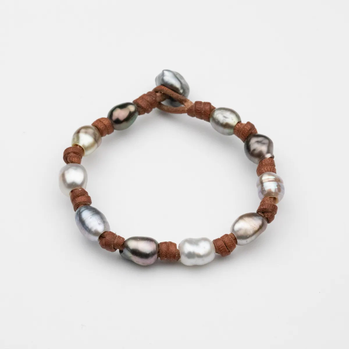 Keshi Pearl leather bracelet with eleven baroque pearls in silver and charcoal tones on rust-brown leather cord with pearl toggle closure — Manos de Oro Saint Barth