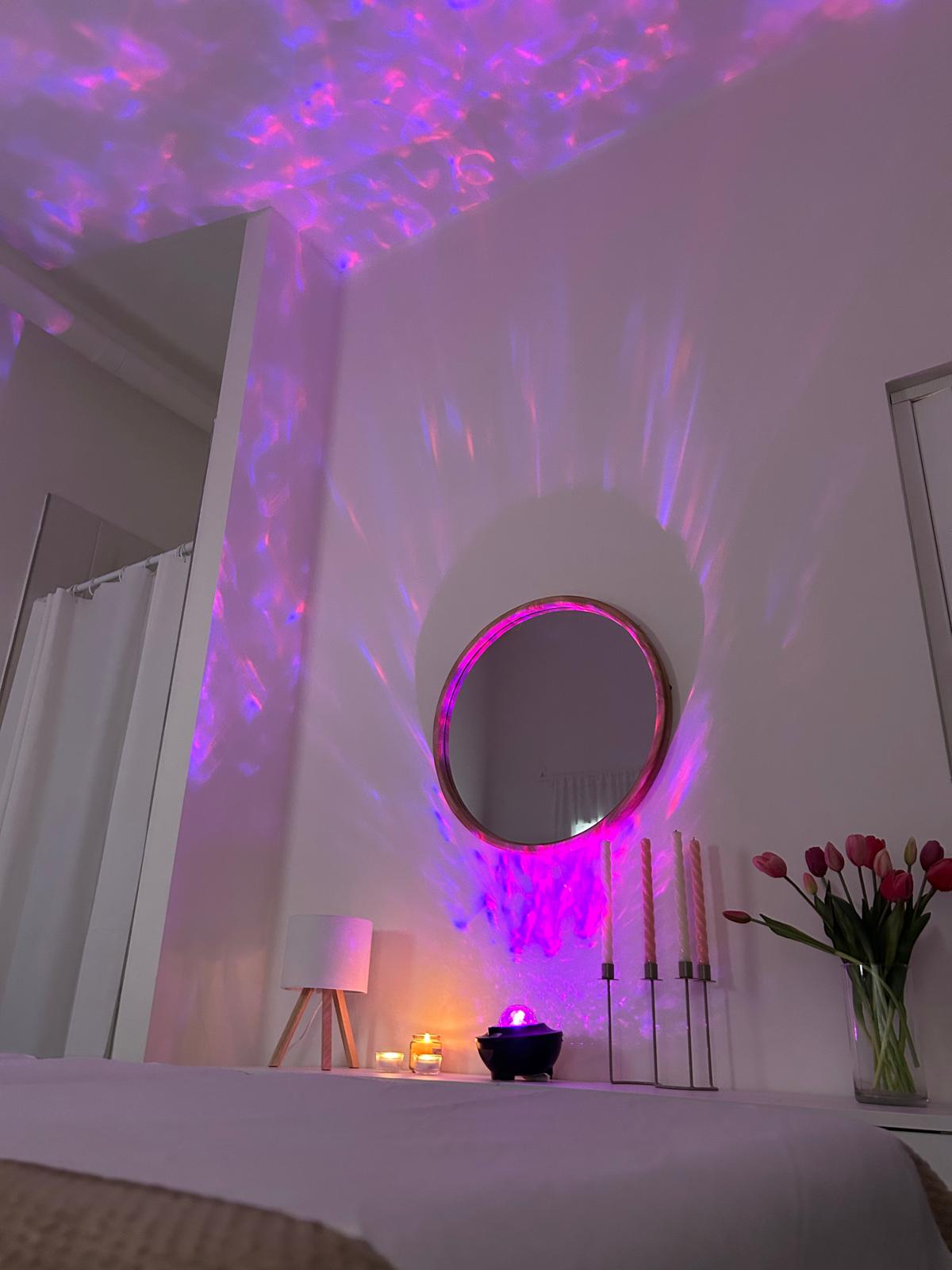 A woman with a white headband relaxing, her face illuminated by warm sunlight filtering through blinds, casting striped shadows. She has a serene and peaceful expression.