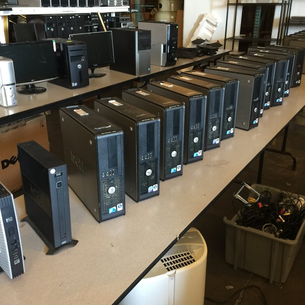 A collection of older desktop computers lined up on a workshop table, ready for trade-in or cashout. These models appear to be standard office PCs, likely equipped with basic hardware suitable for everyday tasks but possibly outdated for modern gaming or intensive computational needs. The setup suggests a recycling or upgrade service, where users can trade in their old PCs as part of a sustainable electronics lifecycle program. This service offers a great opportunity for consumers looking to upgrade to newer, more efficient systems while responsibly disposing of their old equipment.