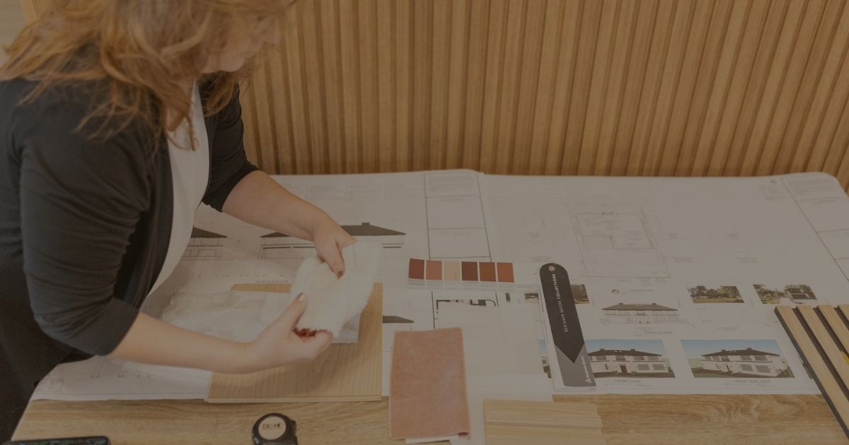A woman looks over house plans while holding samples.