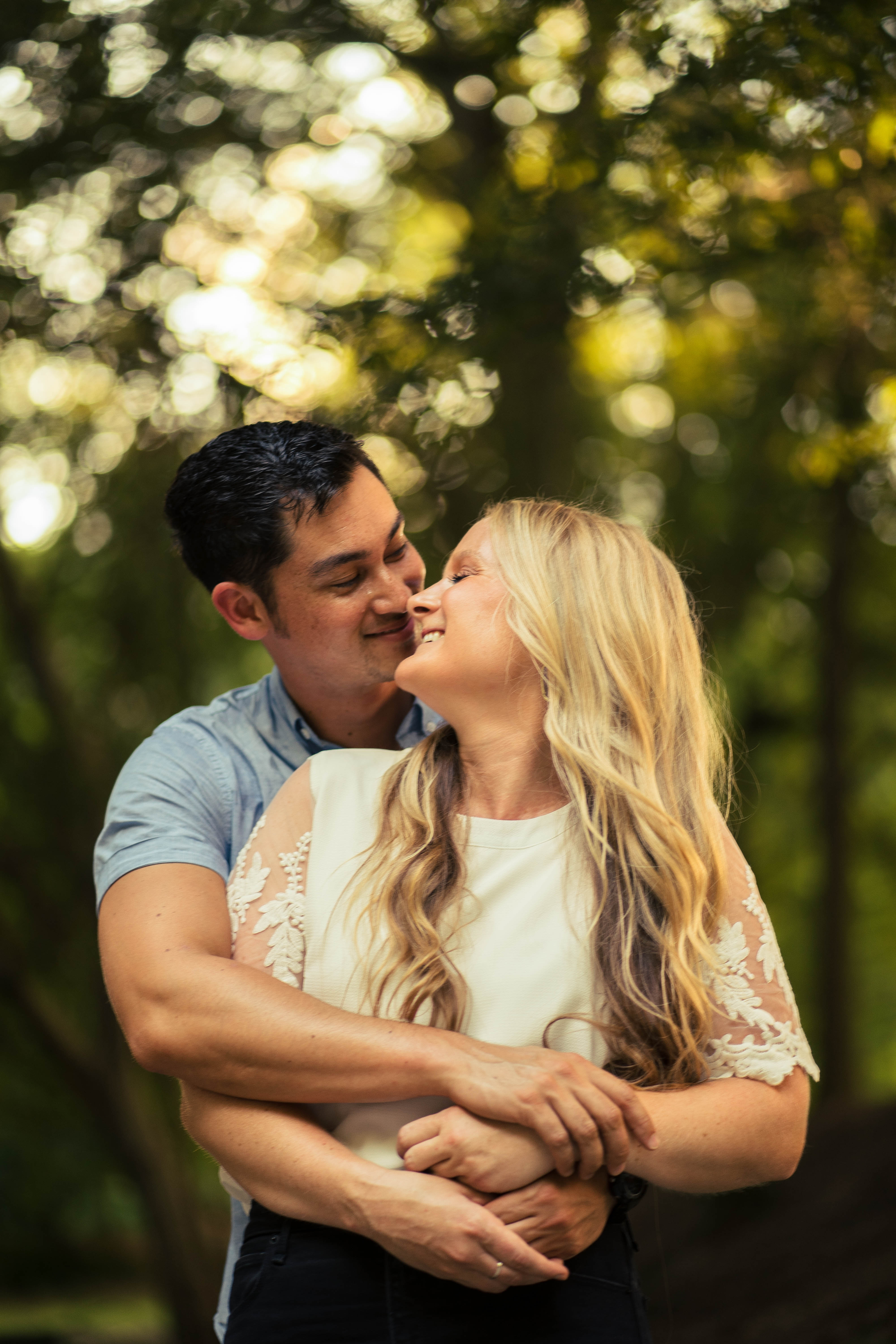 A couple embraces lovingly on a wooden dock.