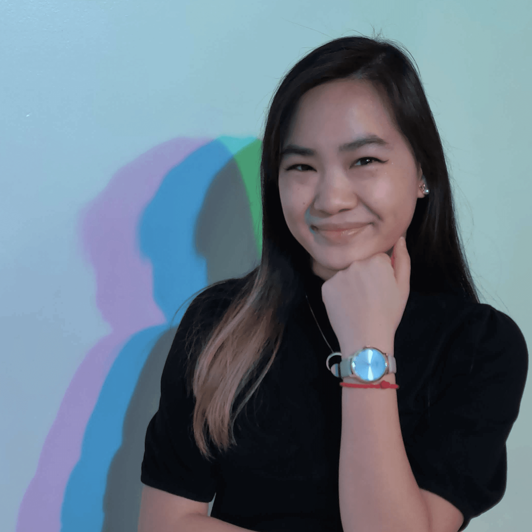 Edith wearing a black shirt against a blue background.