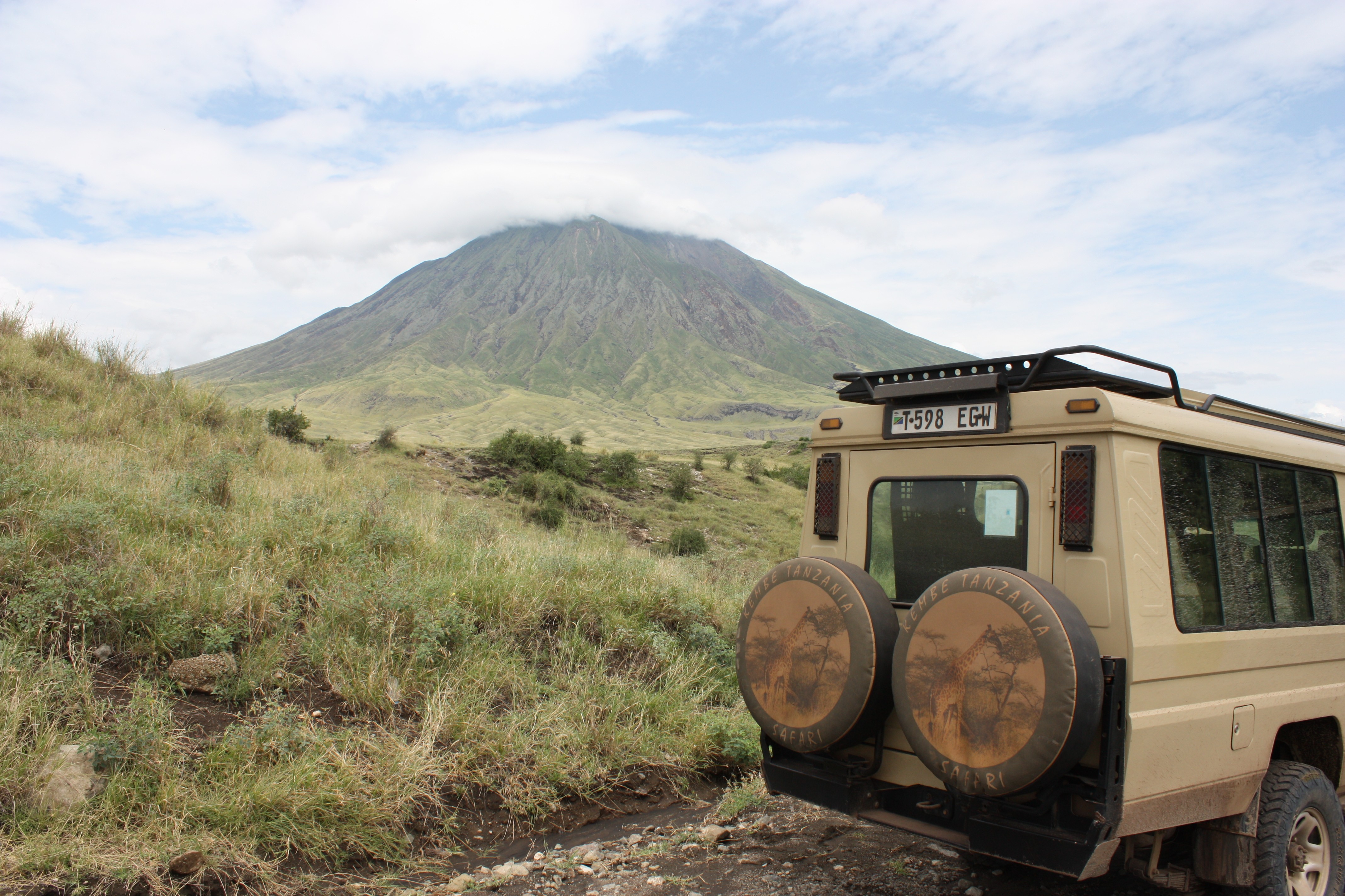 Safari-jeep op parkeerplaats bij JRO luchthaven in Tanzania – Kembe Safari.