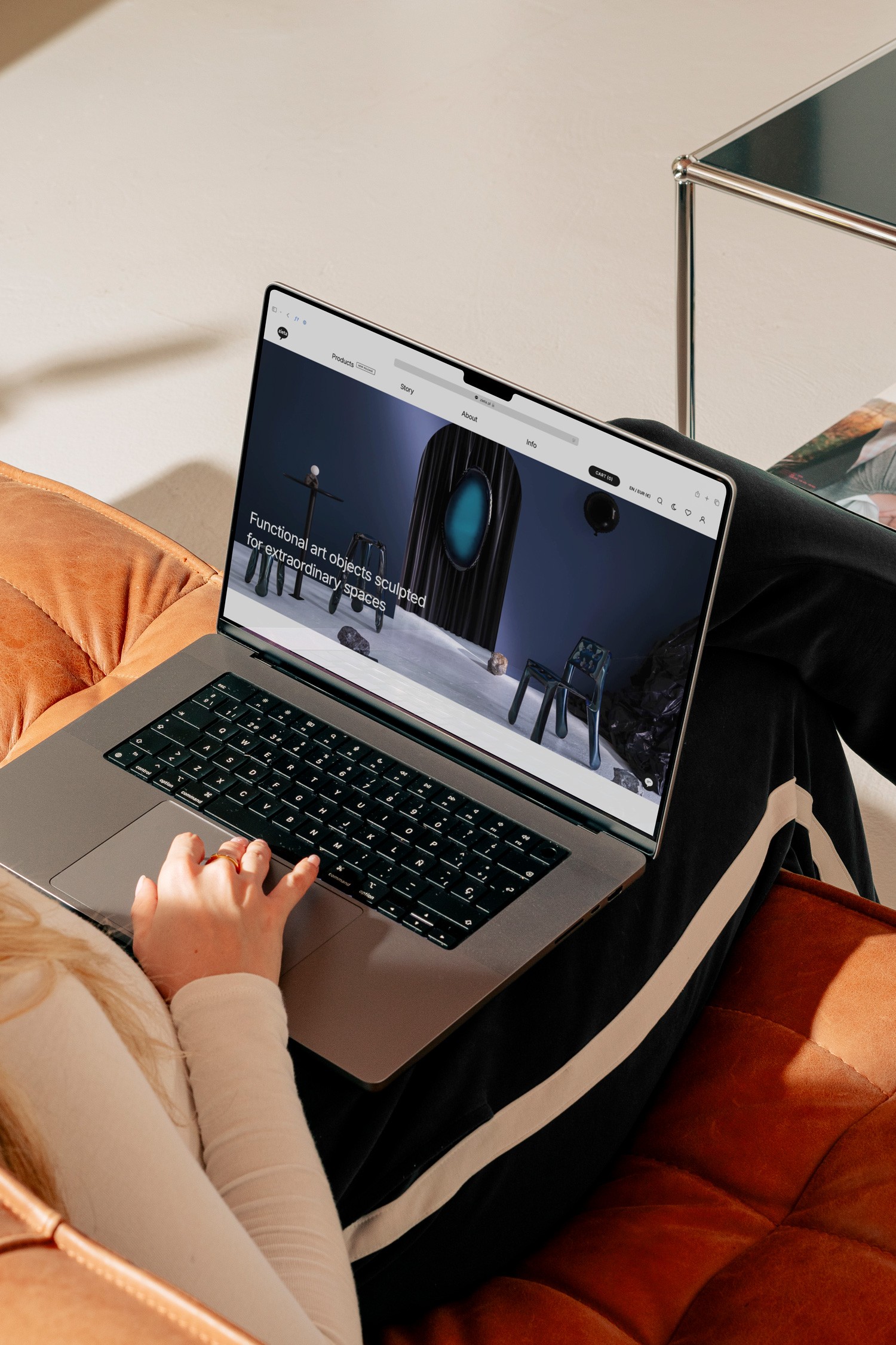 Person using a laptop on a cozy couch, focused on the screen while engaging in an online activity.