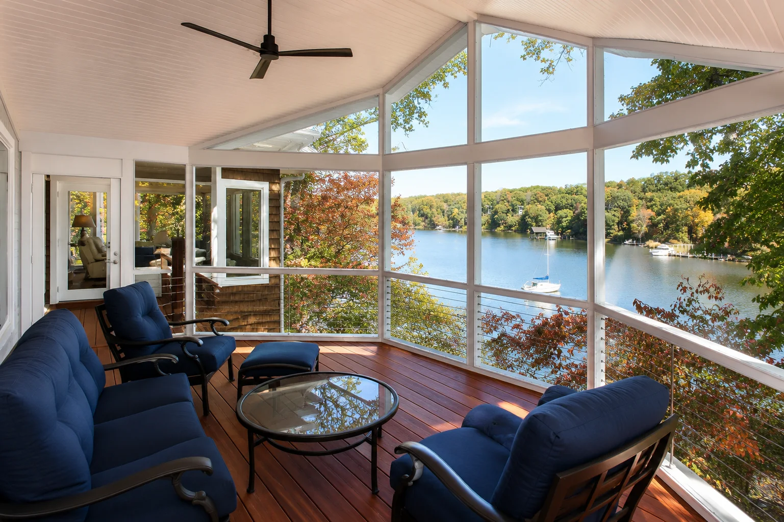 Custom screened porch addition with waterfront views, wood decking, and comfortable outdoor living space