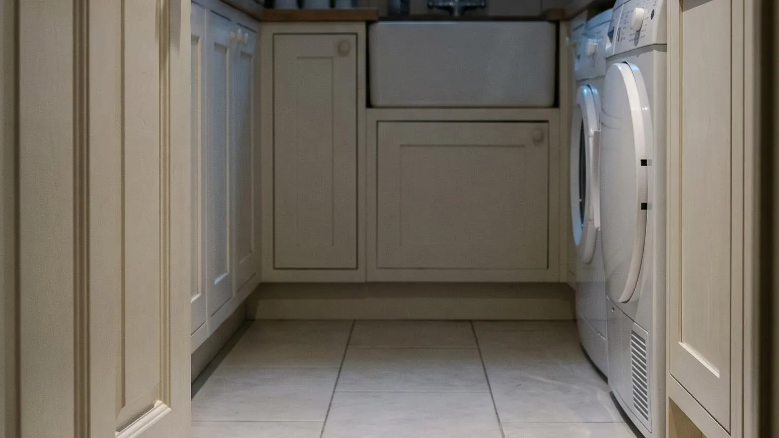 A utility room doorway in the small hours, cool blue light and slippers left by the door
