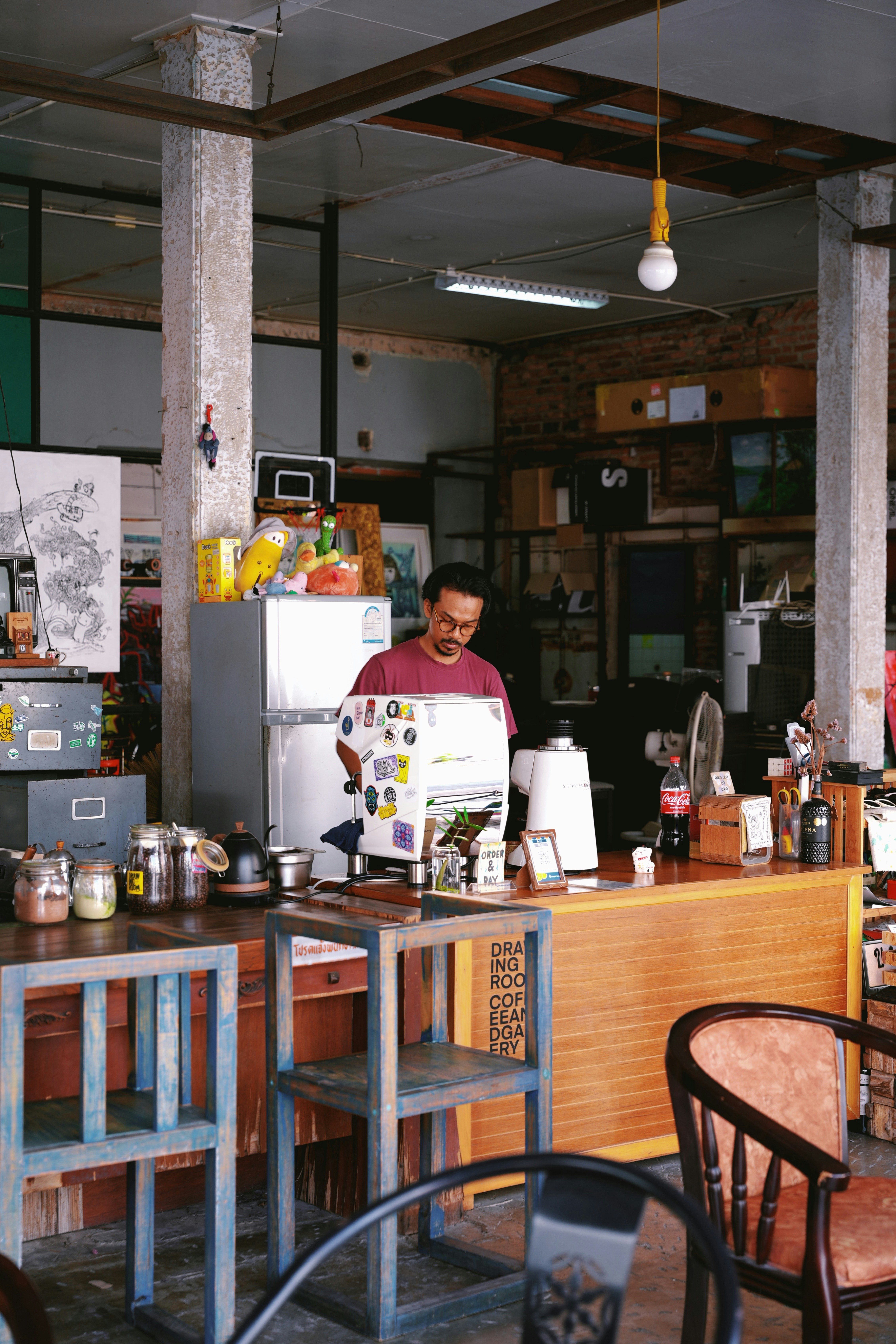 A man standing behind a counter in a restaurant