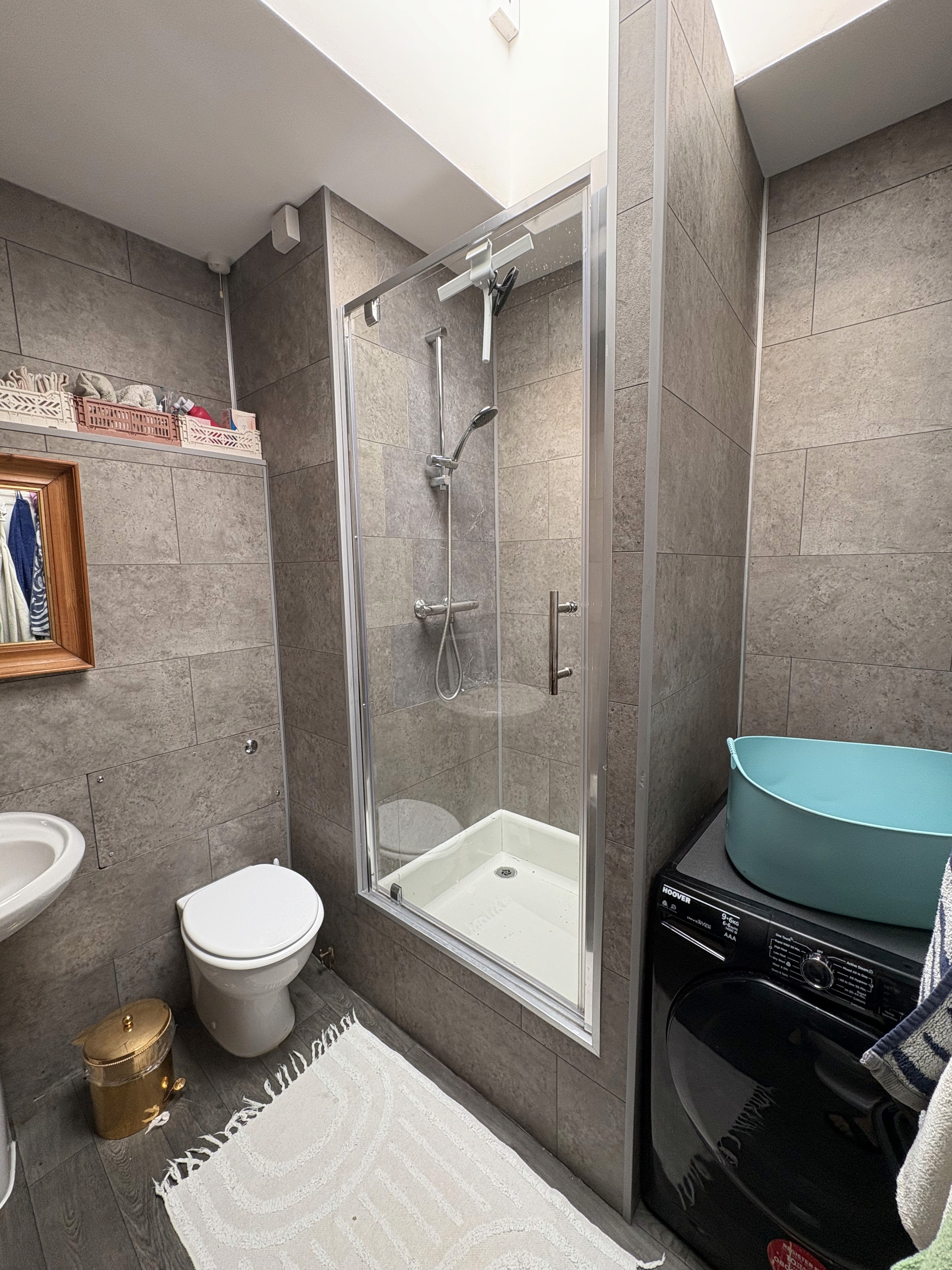 Before: bathroom with dark finishes and minimal storage