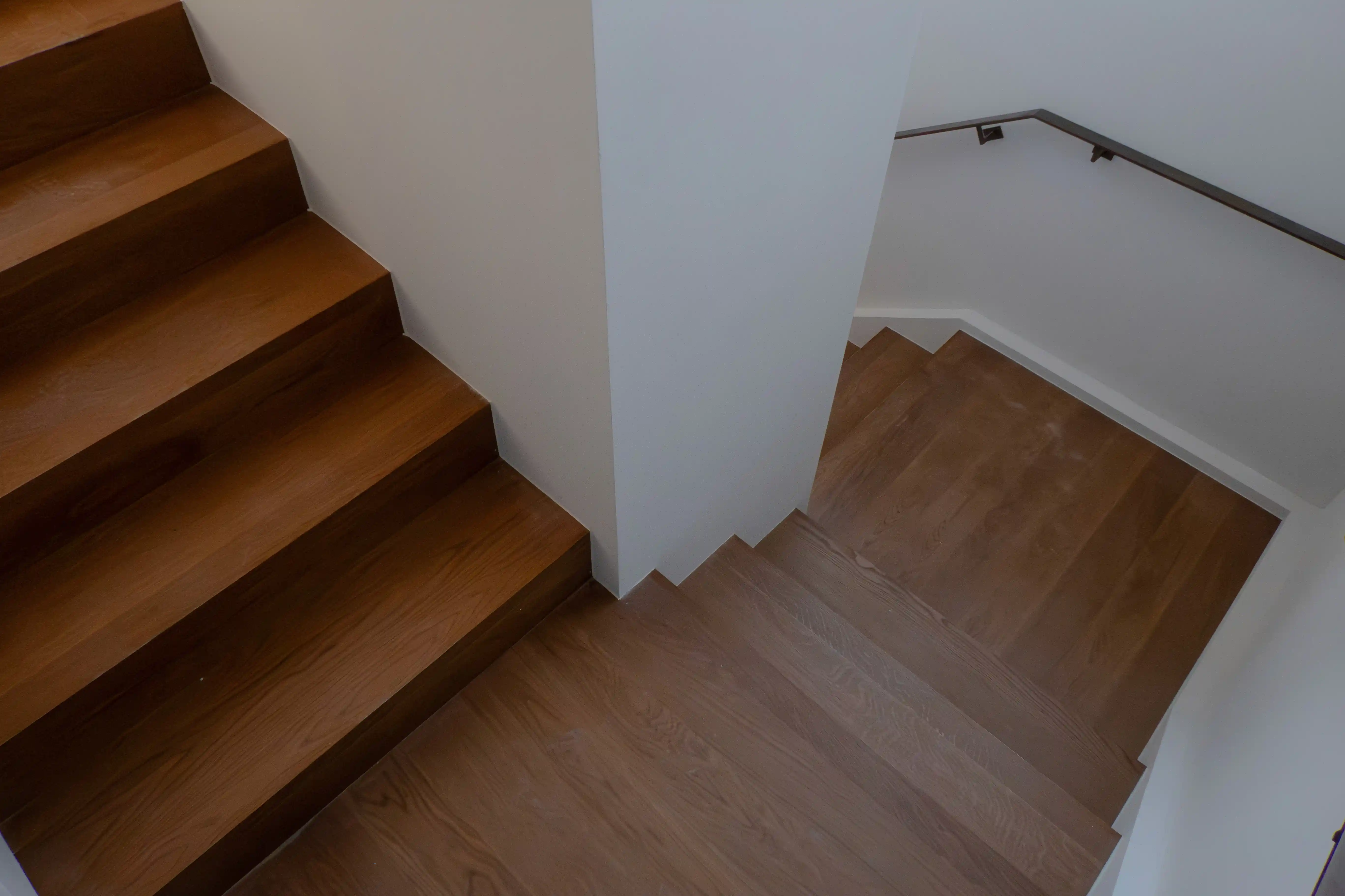 Hochwertig renovierte Holztreppe mit sauber eingepassten Stufen und weißer Wange.