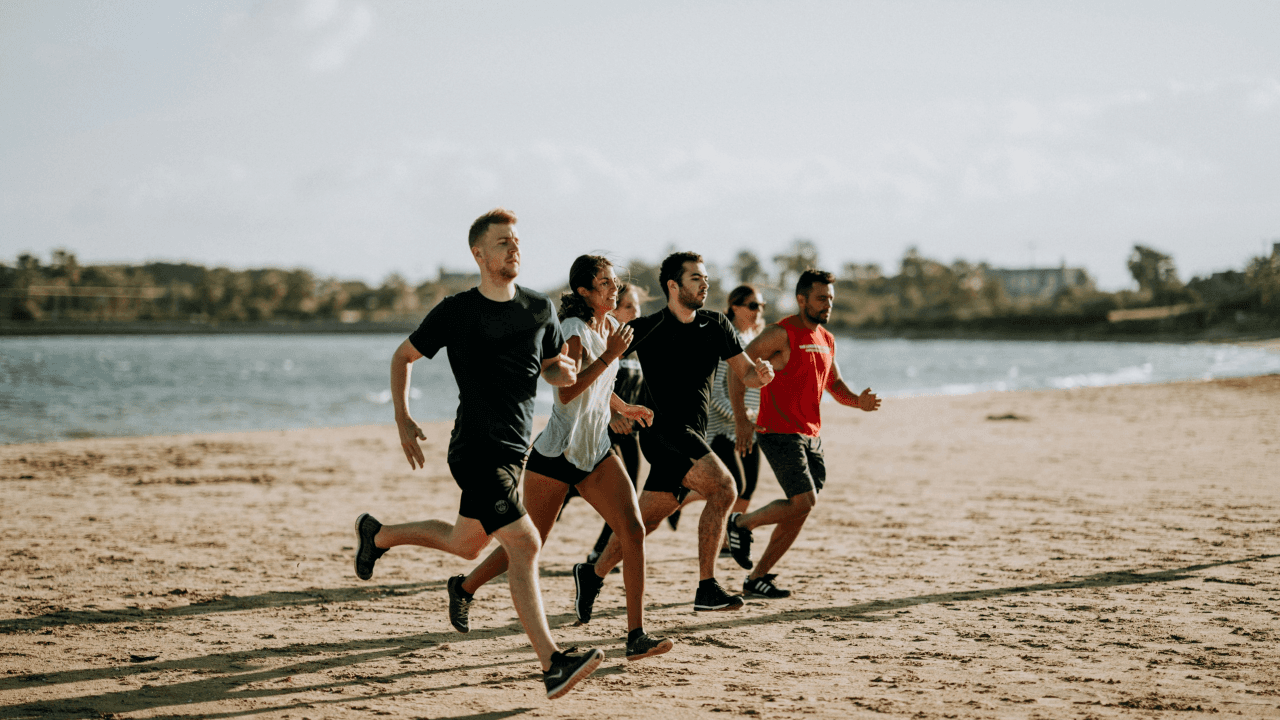 men and women running on sea shore