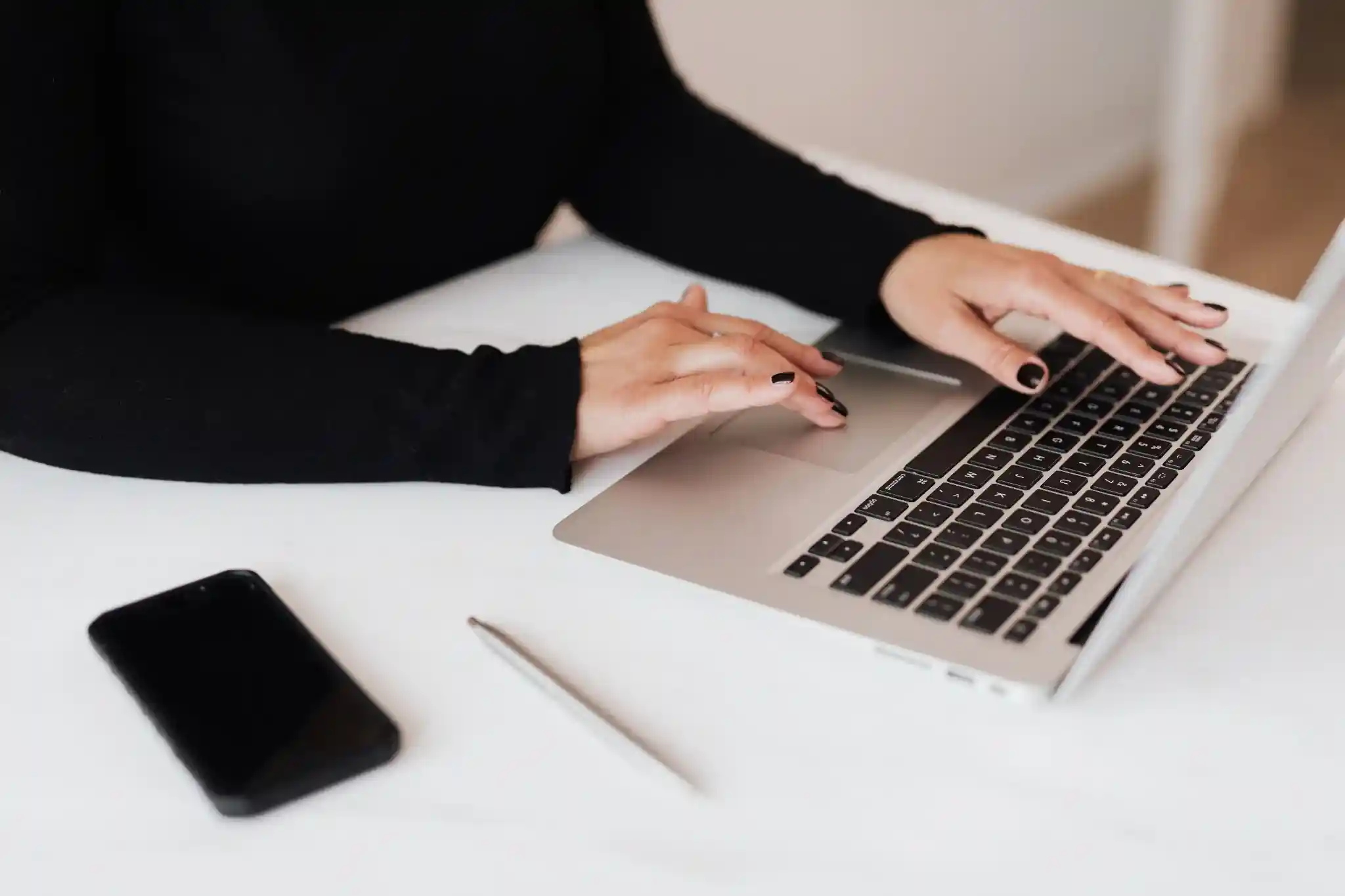 Website designer working on a laptop, representing professional website design and online business growth services.