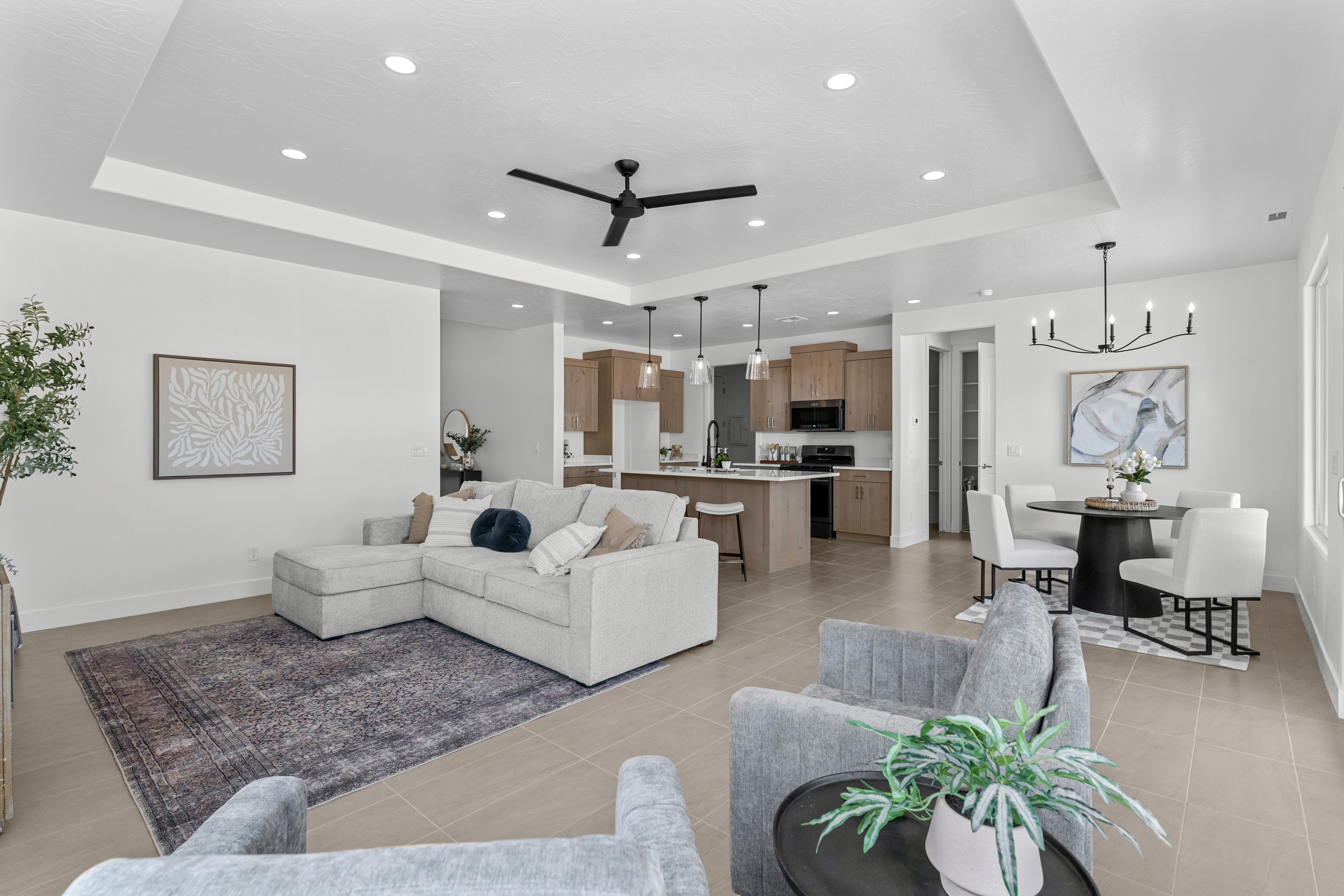 Living room of The Nest at Falcon Ridge in Hurricane, Utah, with raised ceilings and open access to kitchen and dining areas.