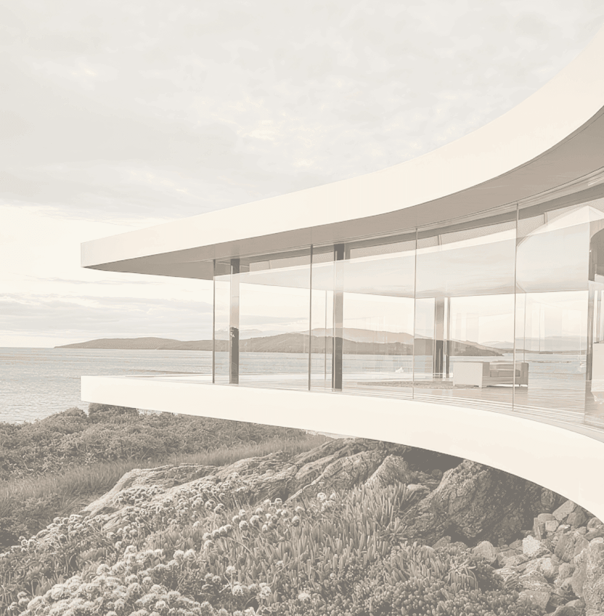 Modern curved glass house on rocky coastline with ocean and island views.