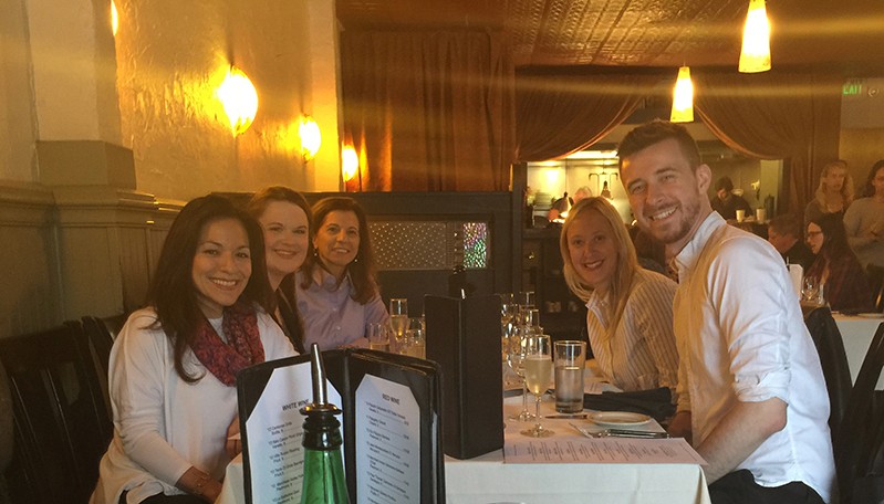 A photo of a group of people sitting at a restaurant table.