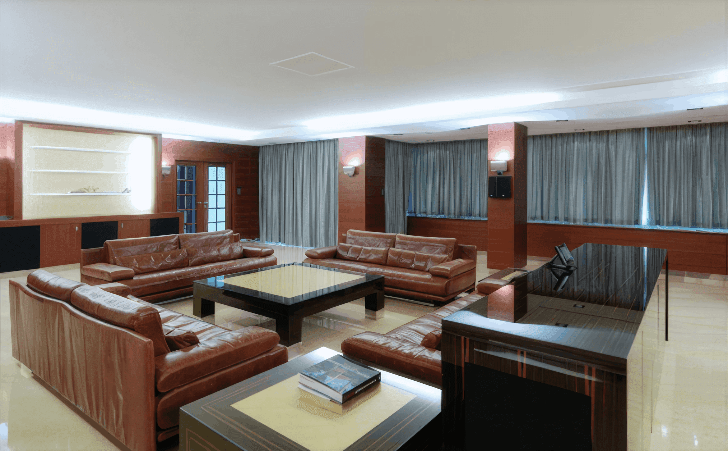 MW Interior  - Großzügiger Loungebereich mit cognacfarbenem Leder und Makassar-Holzvertäfelung im Business Loft" Vier cognacfarbene Leder-Sofas rahmen einen massiven Couchtisch aus dunklem Holz mit Glaseinsatz. Die Raumstruktur wird durch Holzpaneele, indirekte LED-Deckenbeleuchtung und raumhohe Vorhangfassaden gegliedert. Rechts im Bild: ein integrierter Empfangs- oder Schreibtischbereich aus Makassar-Holz.