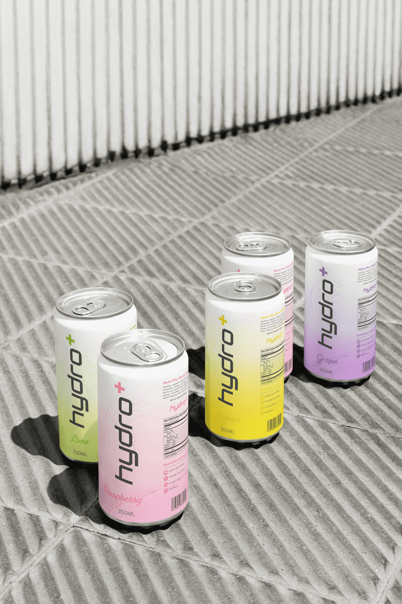 Hydro Plus hydration drink cans in multiple flavours displayed outdoors in natural light.