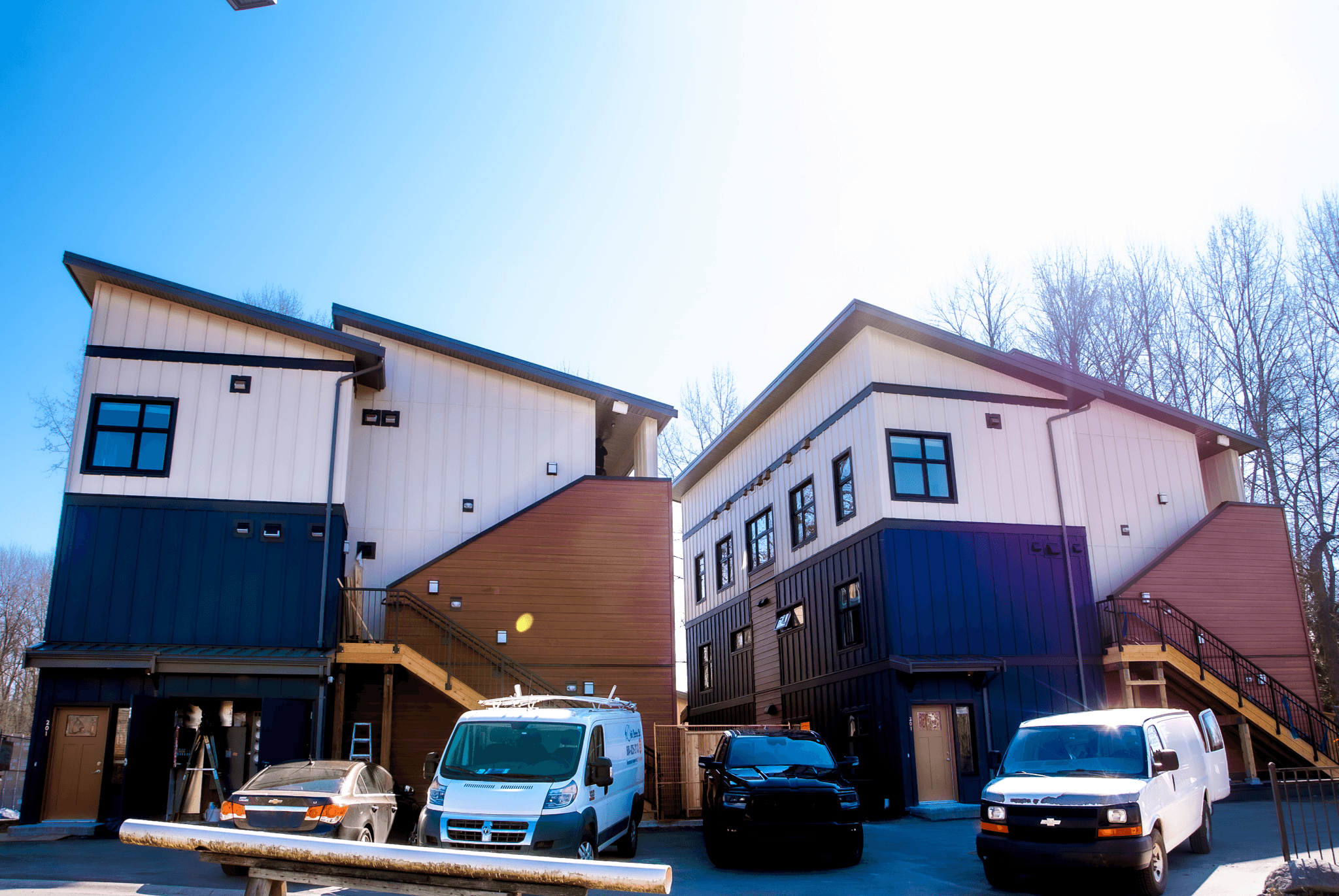 Vehicles parked outside a 14‑Unit Townhouse in Kwikwetlem First Nation, Fraser Valley, British Columbia, with new HVAC and plumbing.