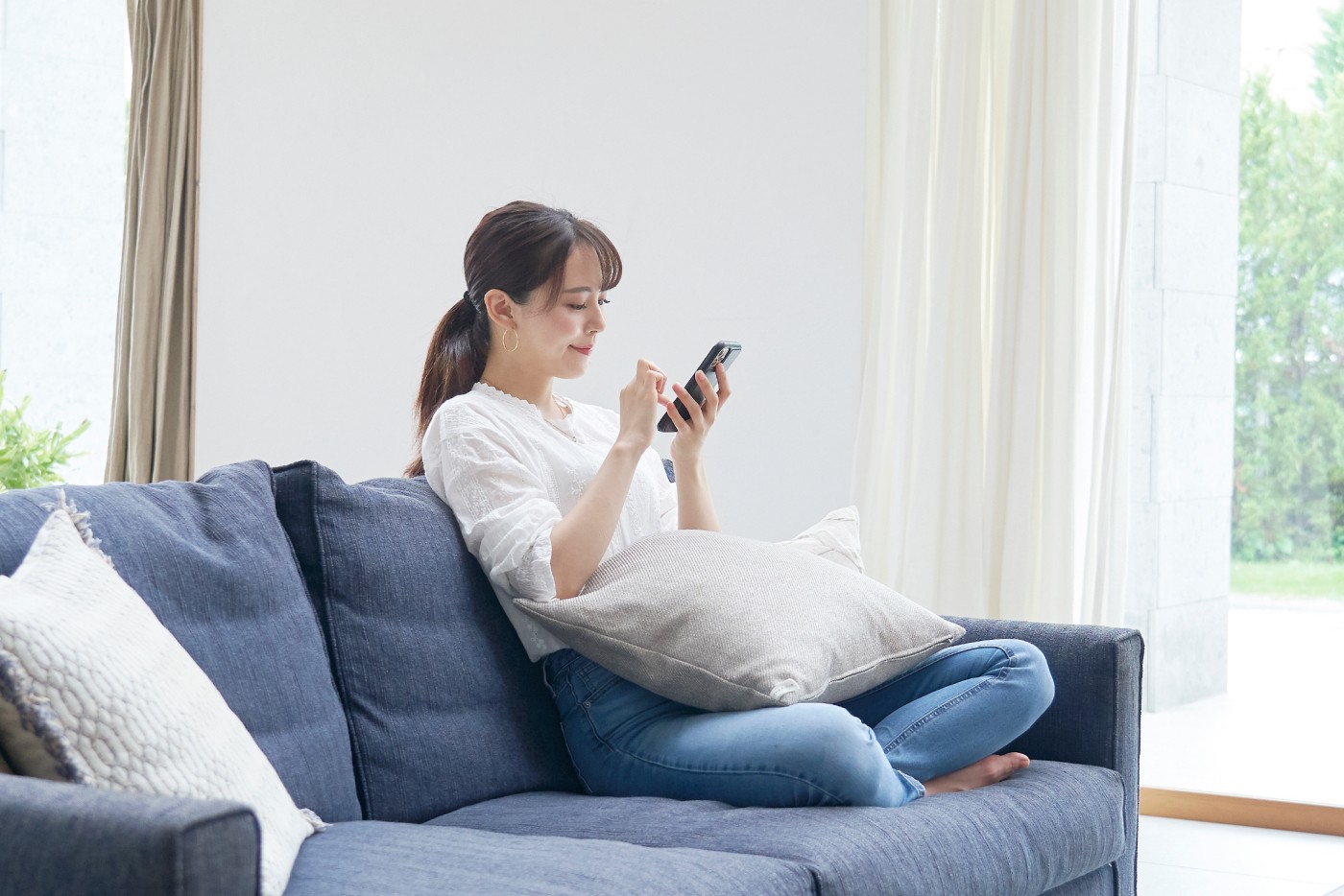 スマートフォンを見て首が曲がっている女性