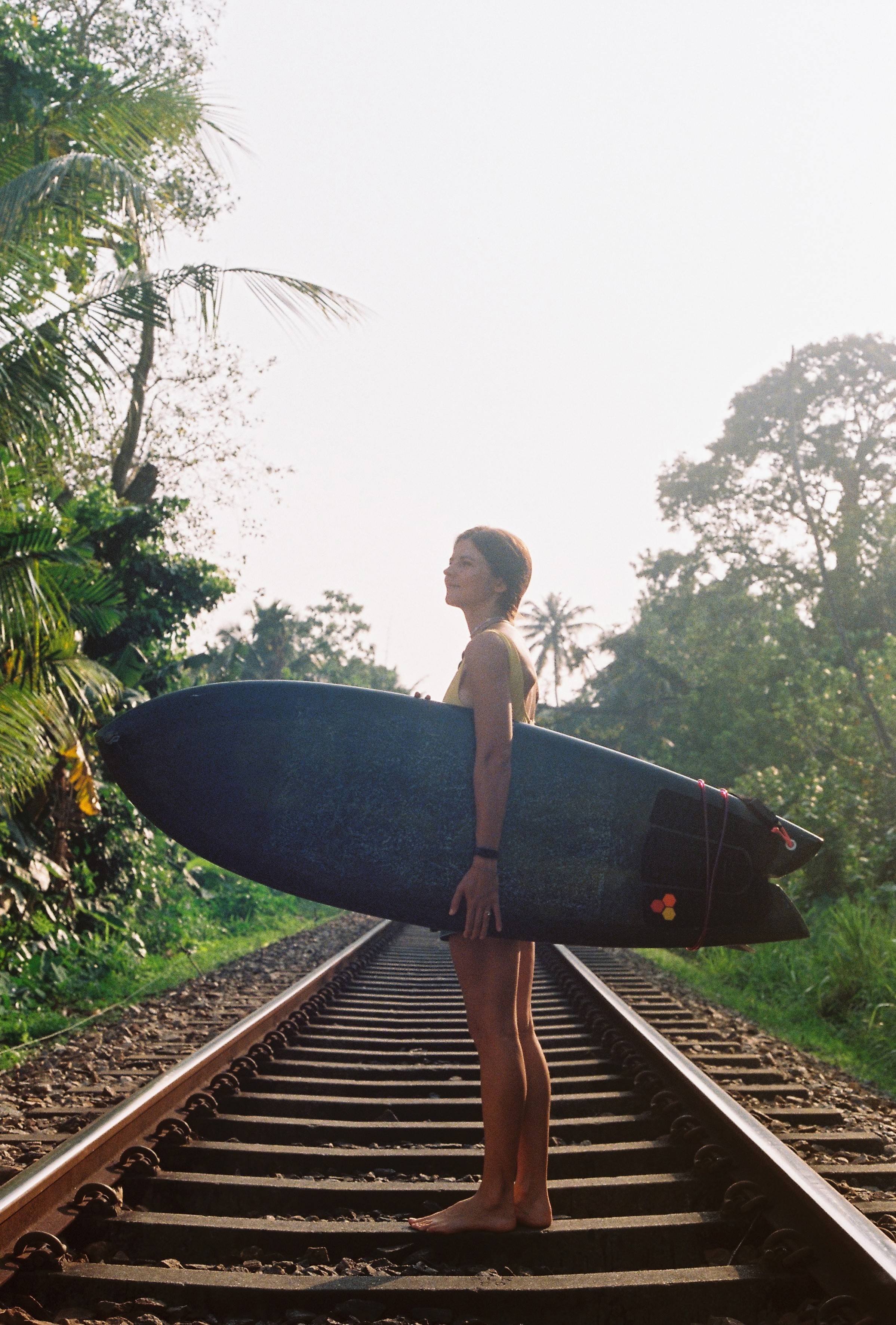 35mm photo of a surfer girl in Sri Lanka on a railwat