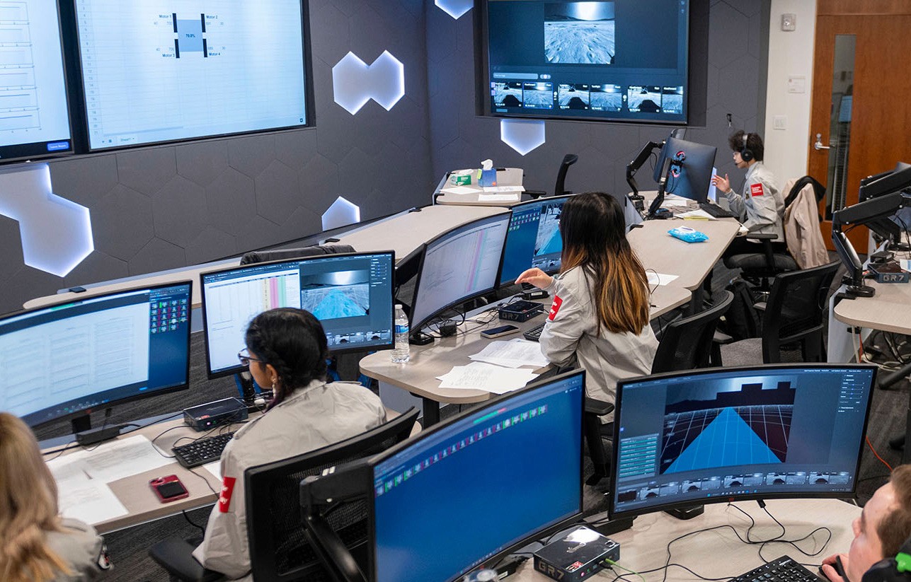Students in a room with many monitors
