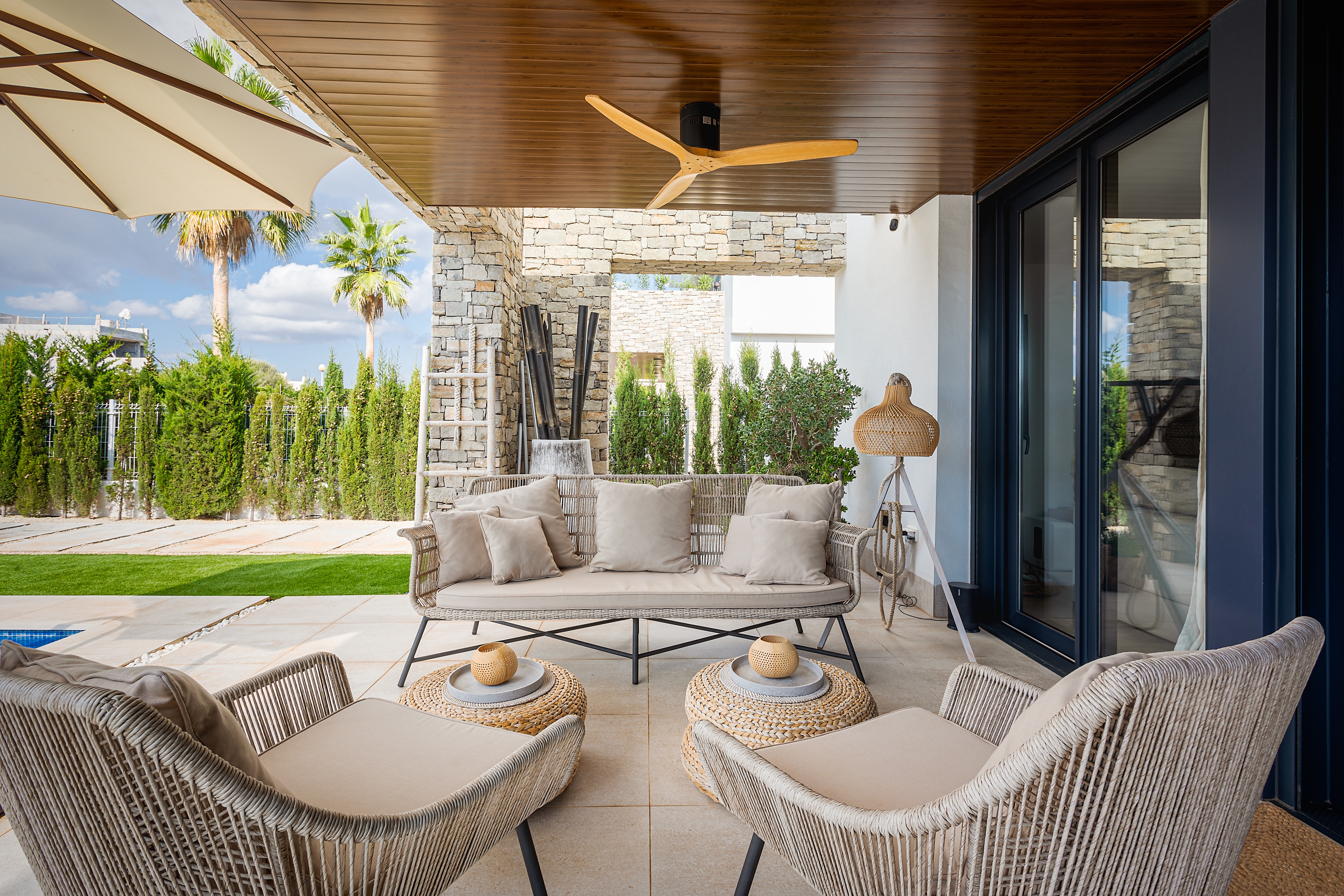 Überdachter Aussenbereich der Beachhouse Villa in Sa Ràpita mit Sitzlounge, Naturmaterialien und Blick in den Garten