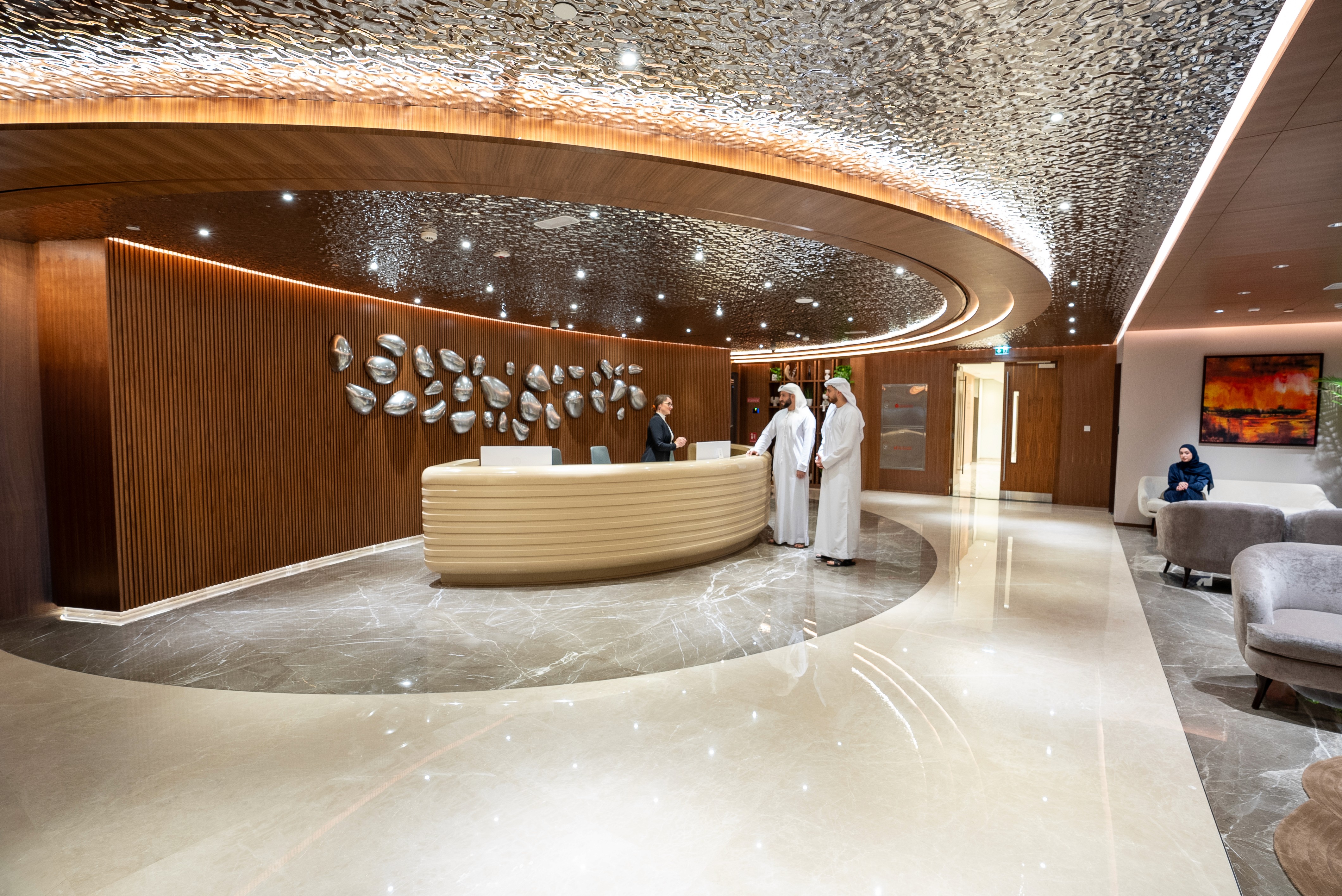 Welcome area of Office Square’s serviced office in Abu Dhabi, featuring curved architecture and artistic ceiling lighting.