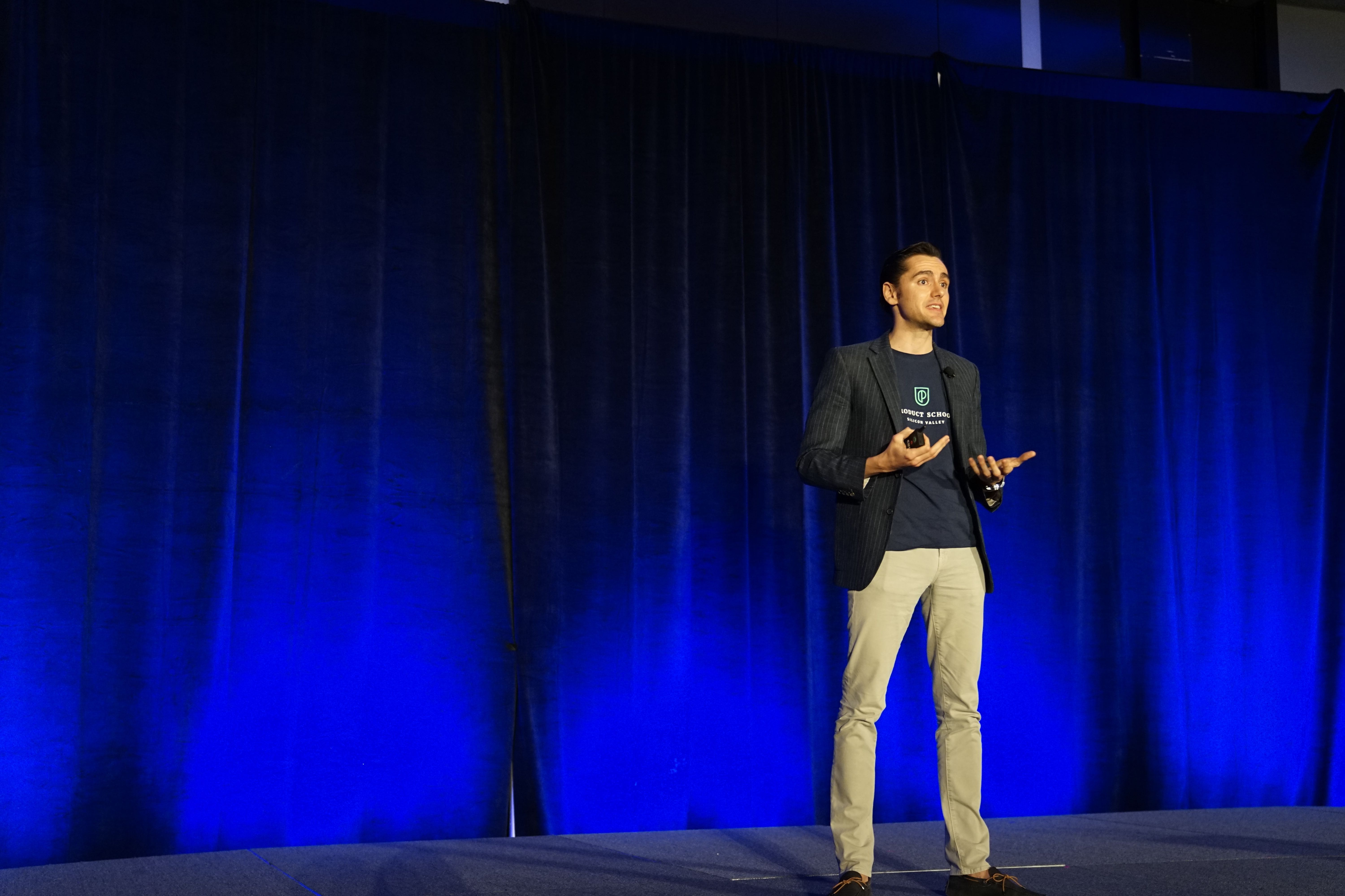 A person standing on the stage delivering a talk