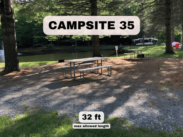 Campsite 35 at Pine Hollow Campground, a 32ft pondfront RV site with a picnic table and shaded gravel pad