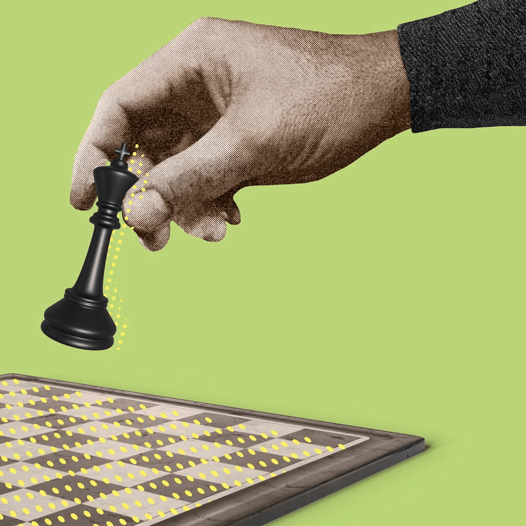 Mano sosteniendo una pieza de ajedrez sobre un tablero, simbolizando estrategia y toma de decisiones.