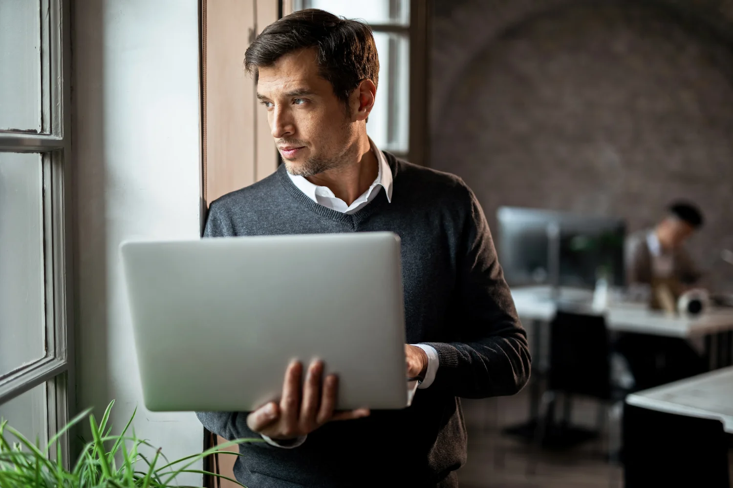 Business professional reviewing enterprise operations and governance processes using a laptop in a modern office environment.