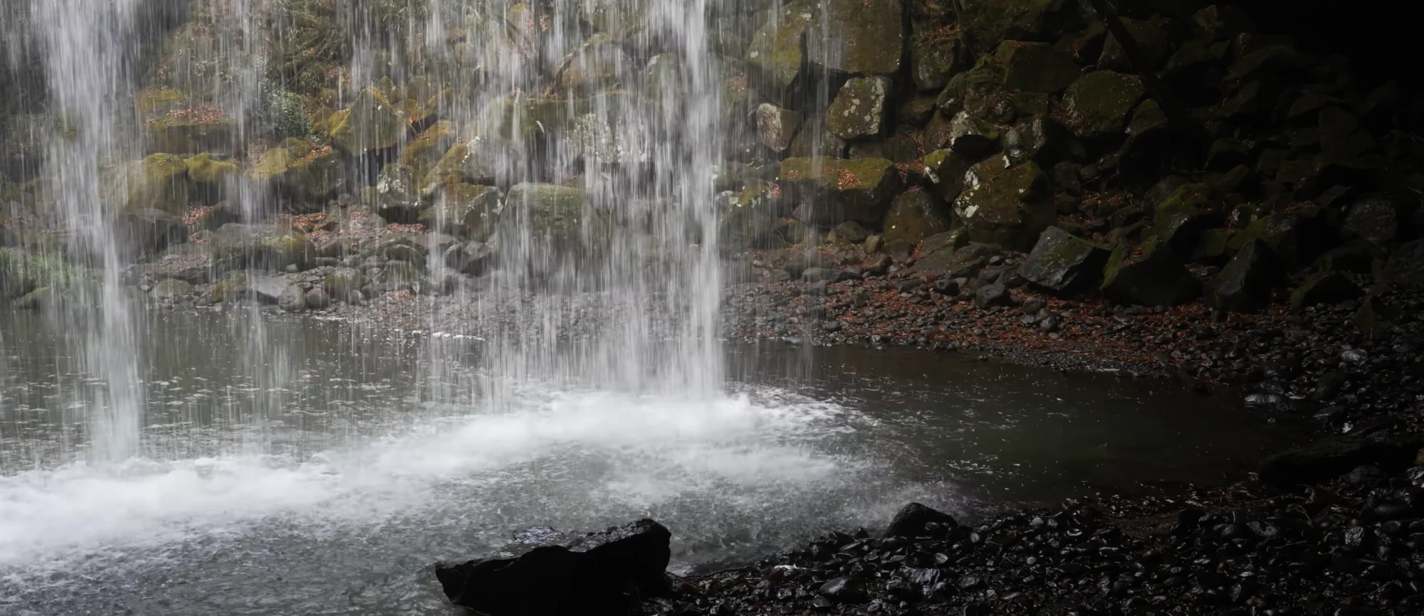 Nabegataki Falls dropping in a wide sheet into a shallow stony plunge pool