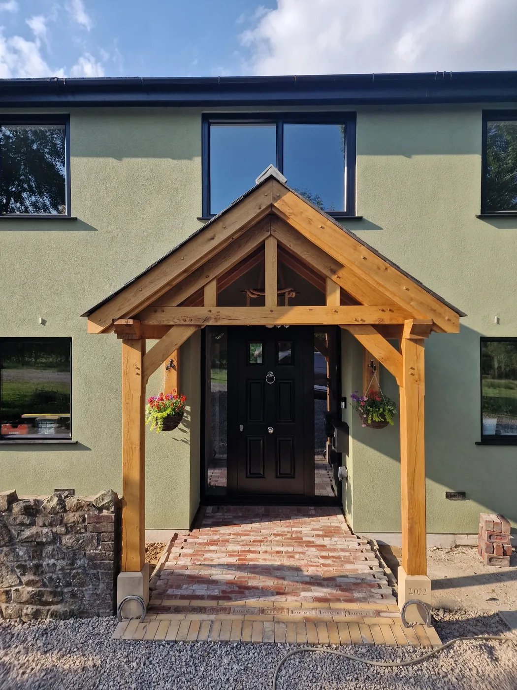 The finished oak porch on the rendered house