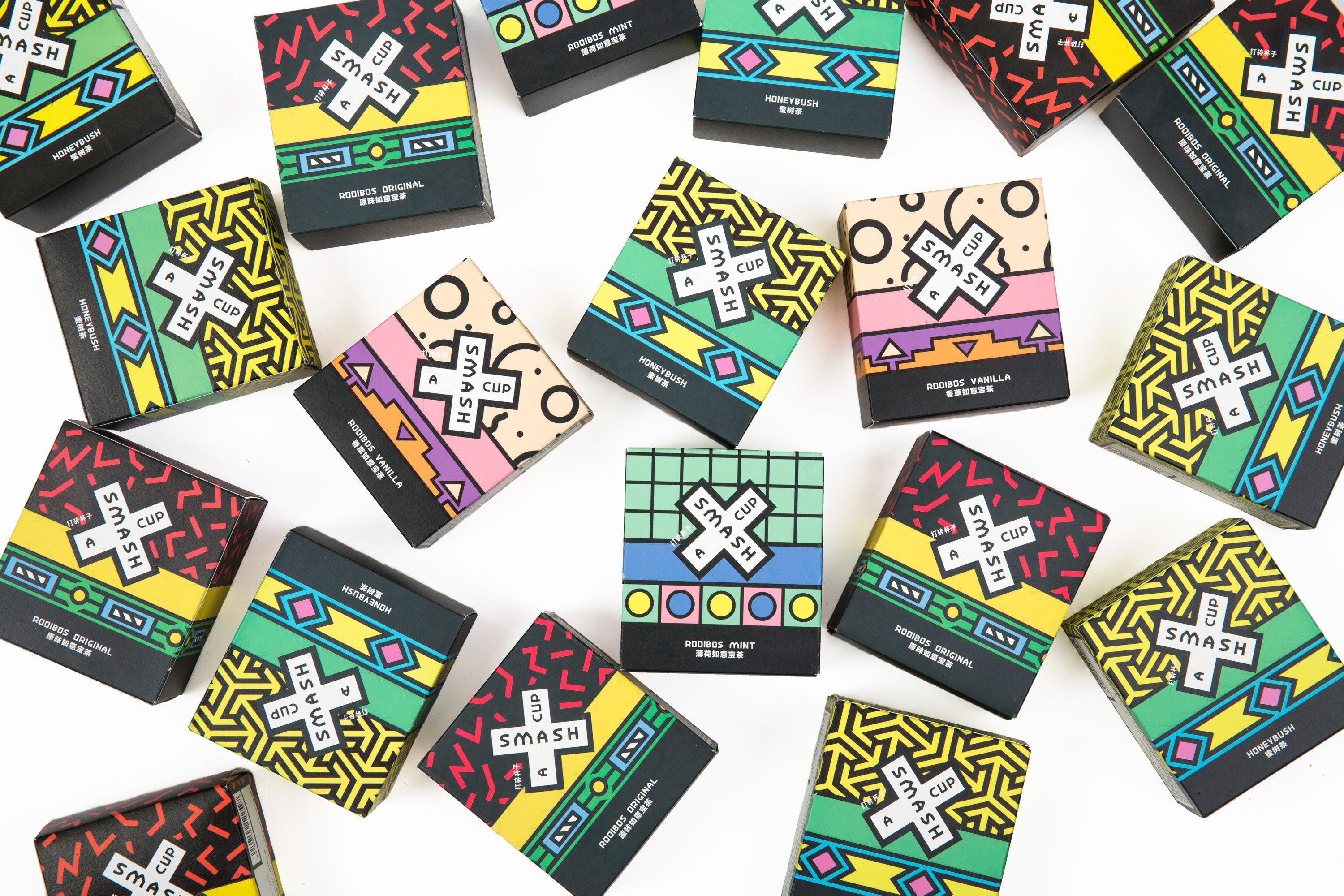 A photo showing colored boxes with patterns and a white X in the middle. The text on the whit X is: Smash A Cup.